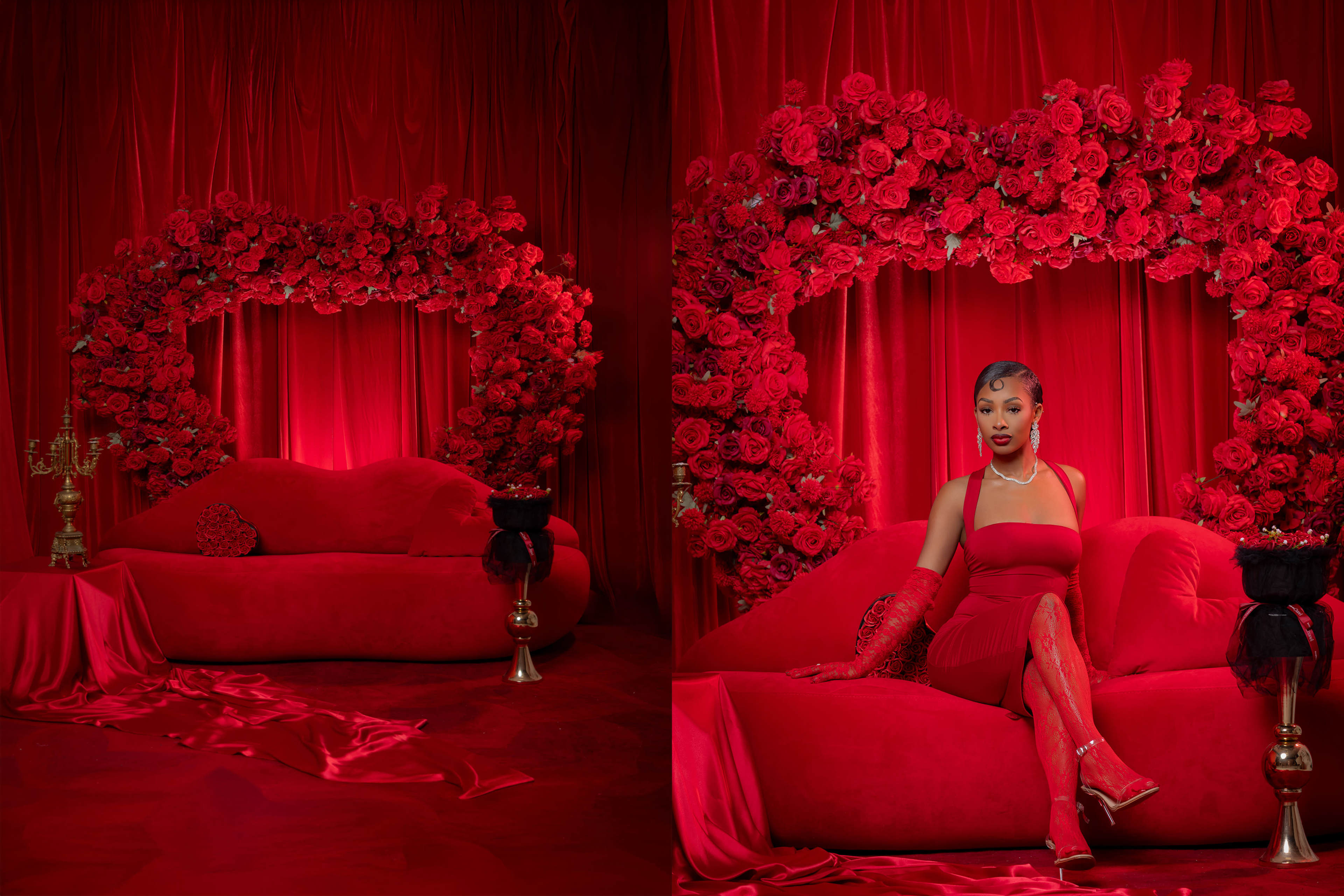 A woman in a red dress sits on a plush red sofa surrounded by a heart-shaped arrangement of red roses against a matching backdrop.