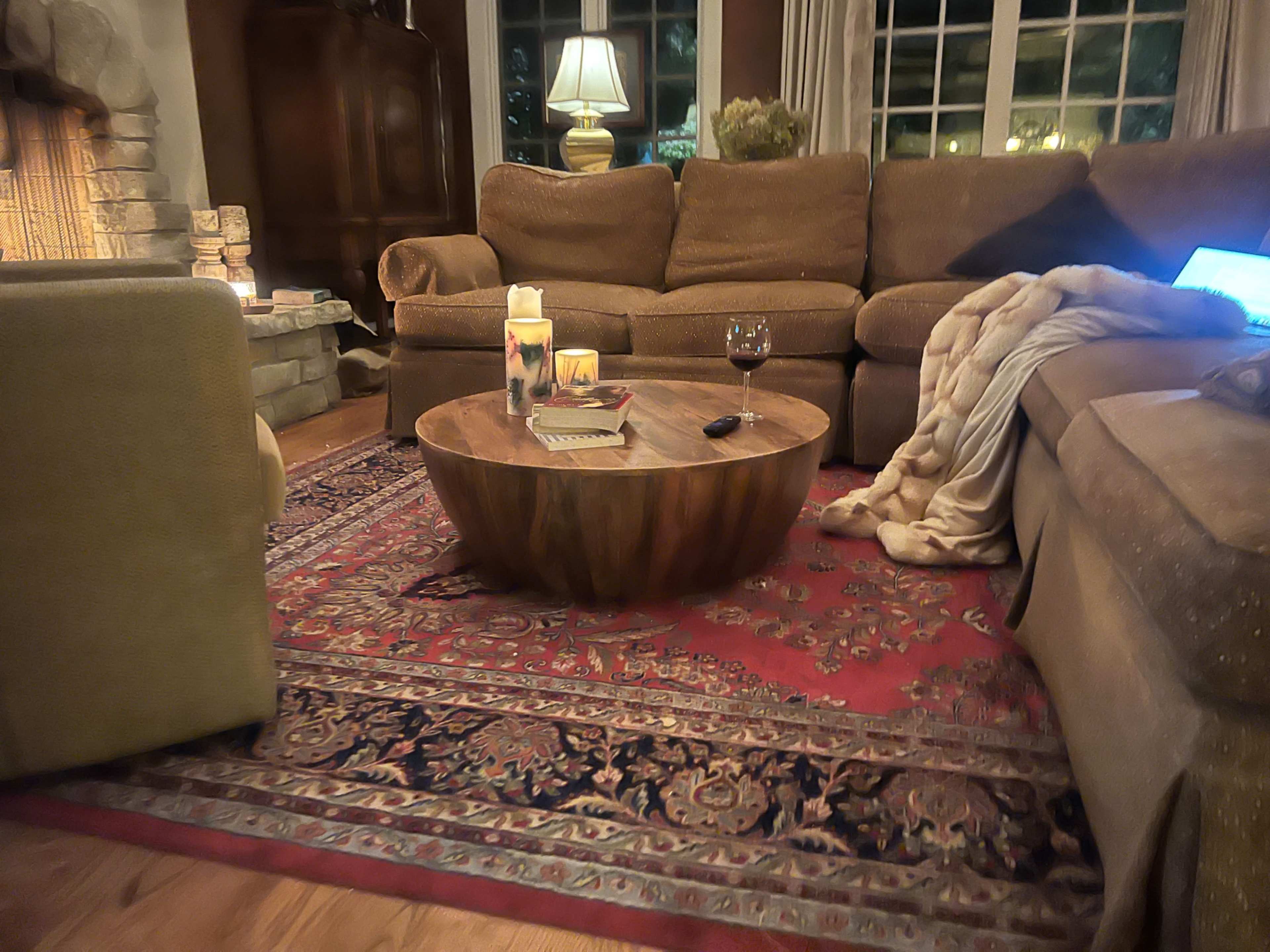 The living room features a cozy arrangement of a sofa and chairs surrounding a wooden coffee table on a decorative rug.