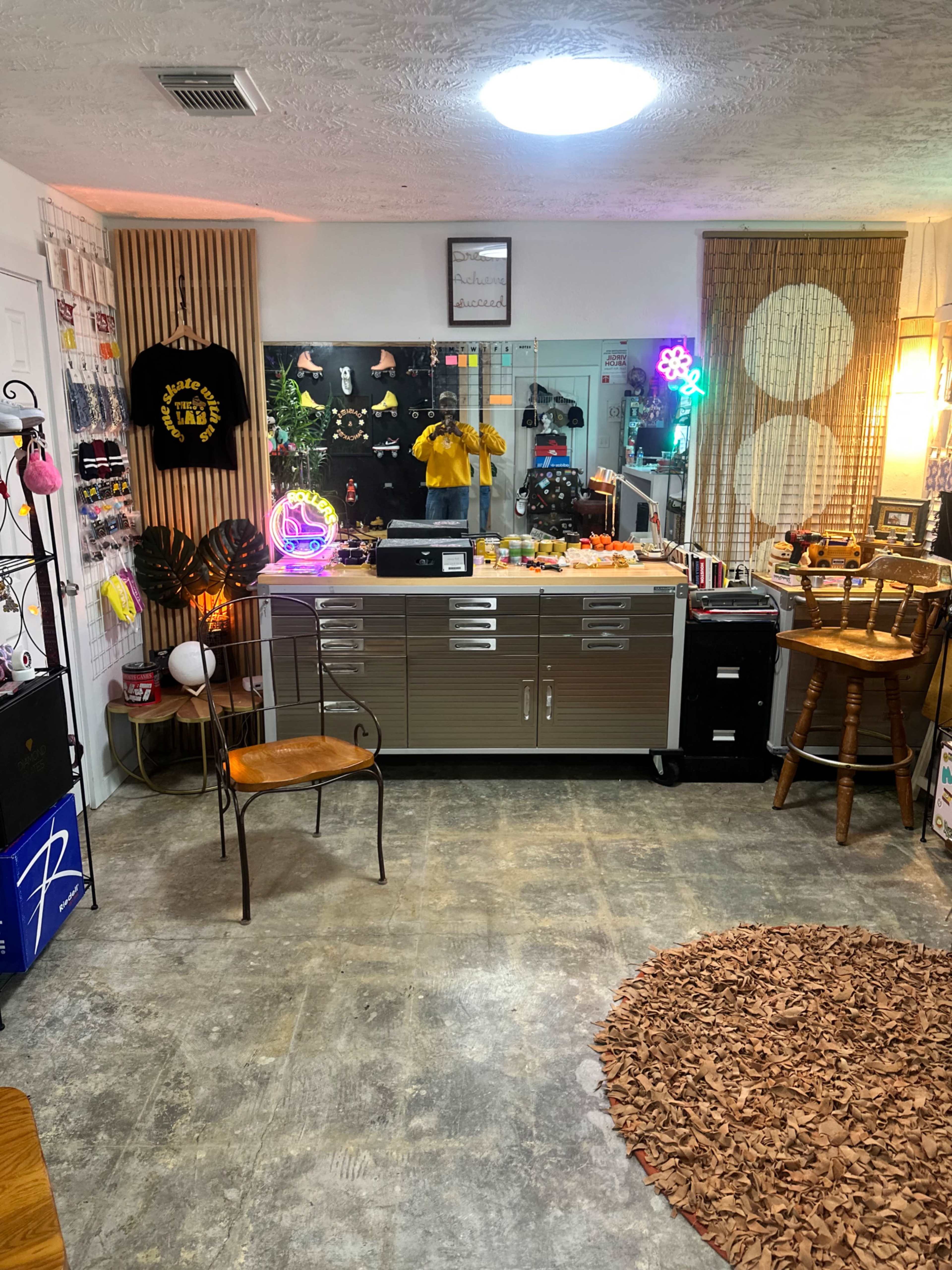 The image shows a well-organized room featuring a display counter, various decor items including neon lights, and seating arrangements.