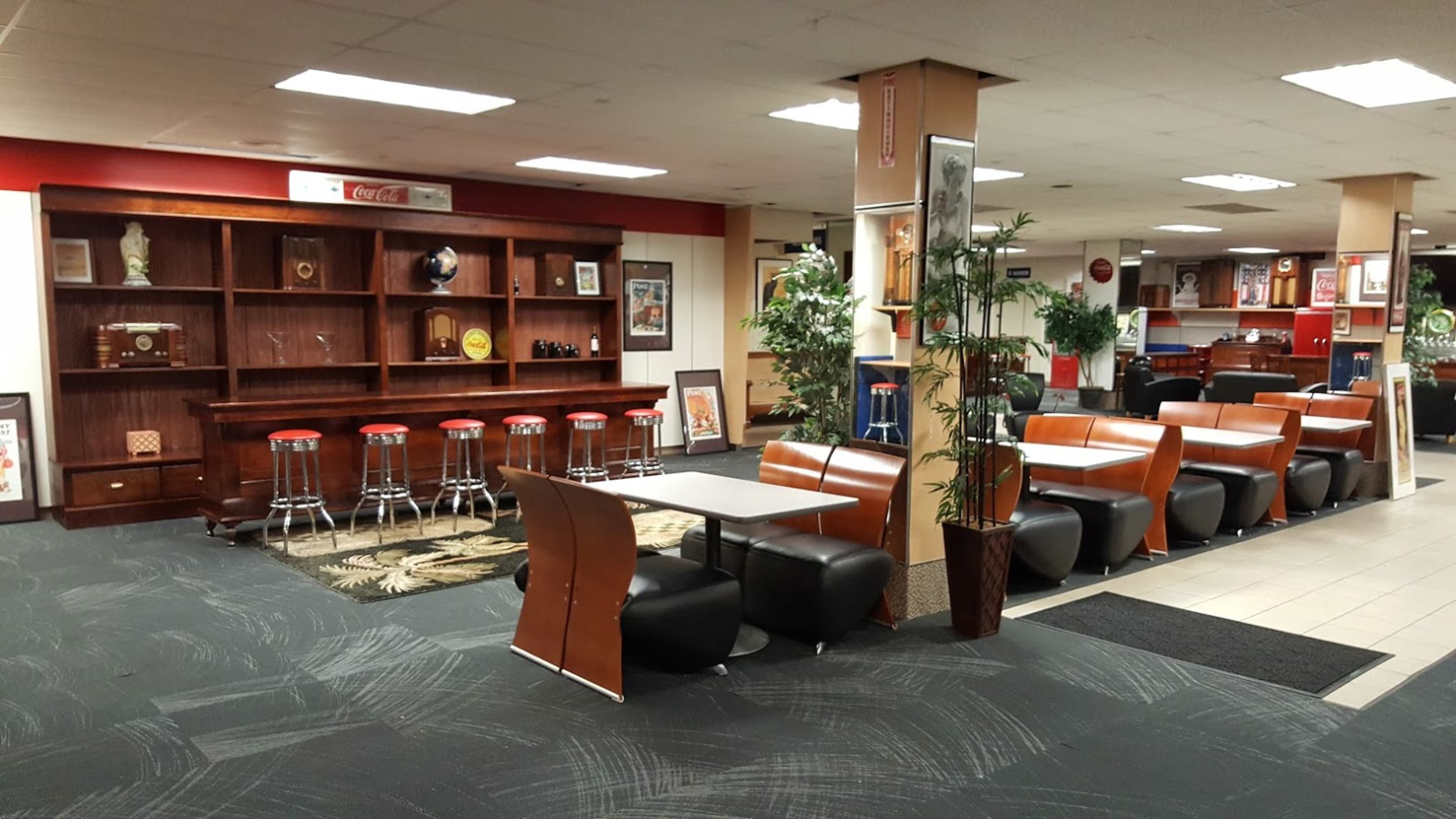 A spacious, modern dining area with leather seating, a wooden bar, and decorative artwork on the walls.