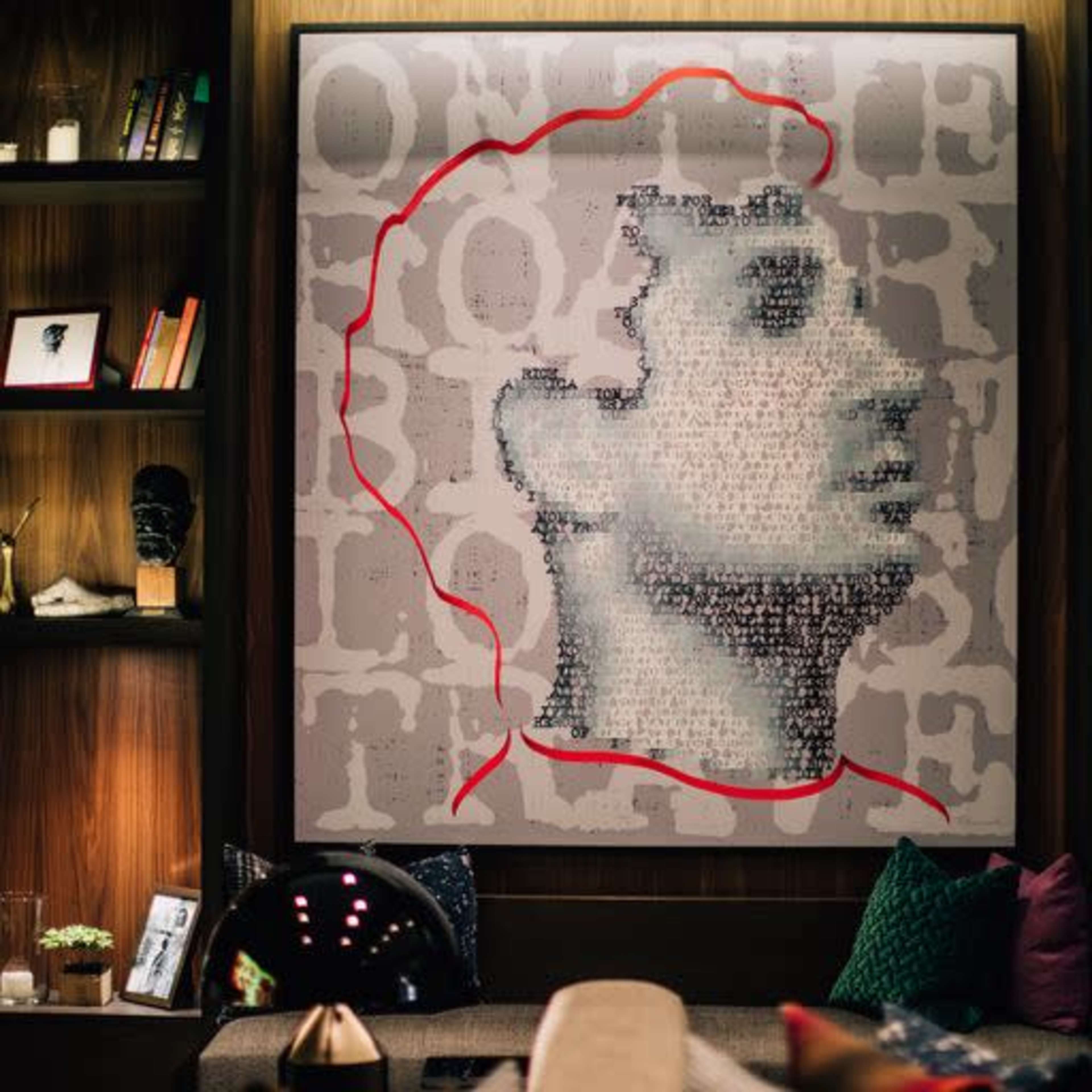 A modern interior space showcasing a large wall art piece that depicts a human silhouette composed of text, with red outlines accentuating the figure against a wooden backdrop.