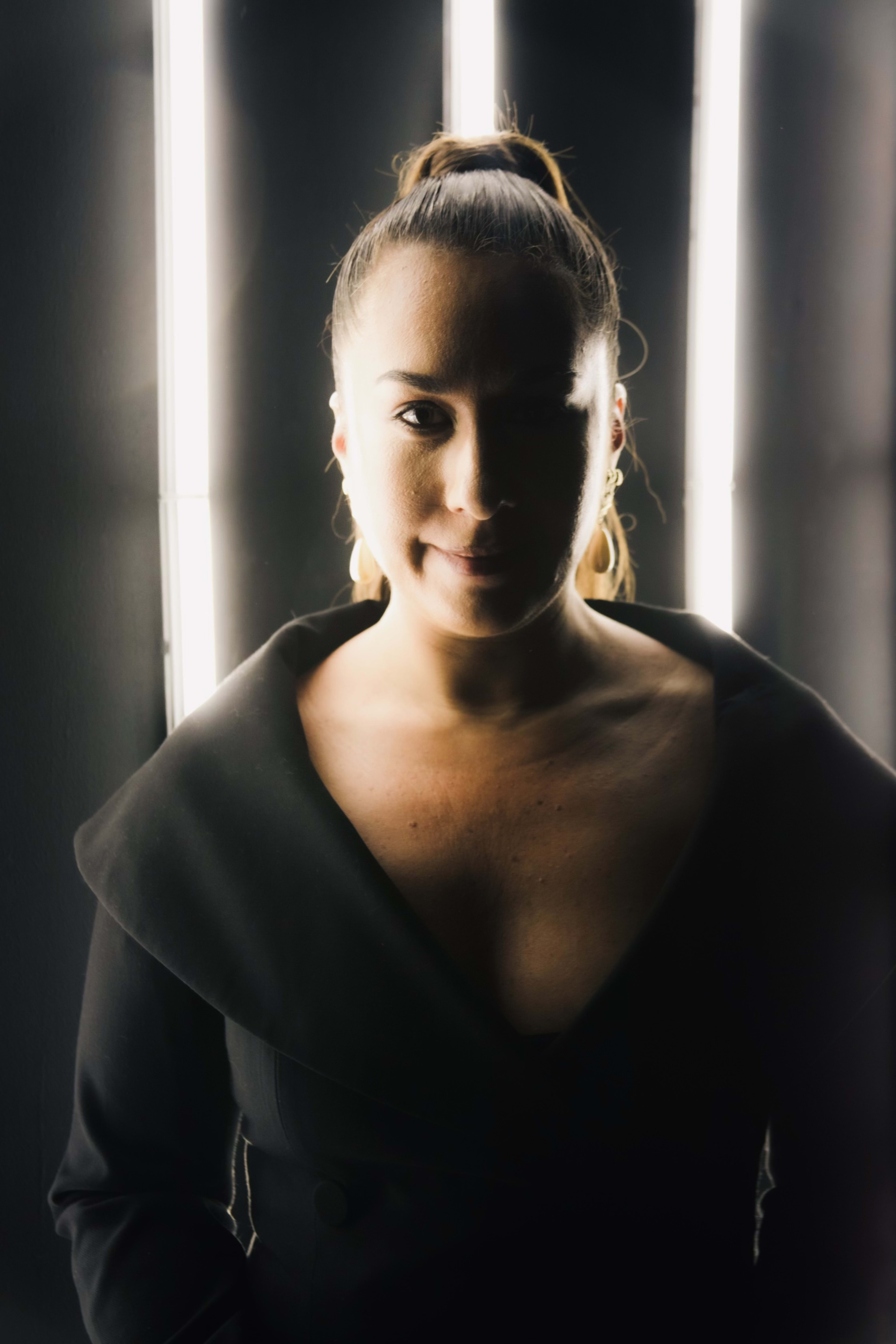 A woman posing for a black dress photo shoot.