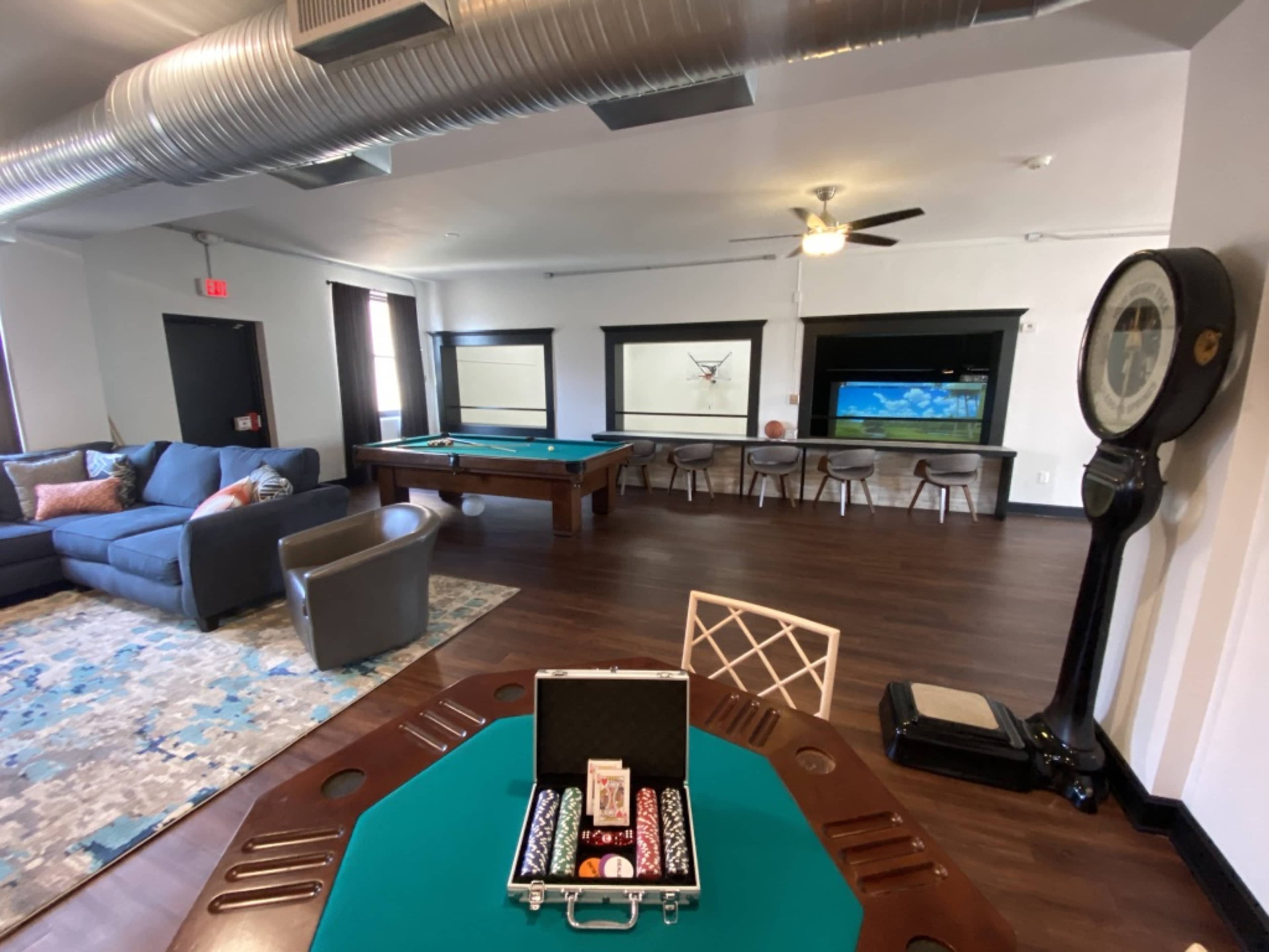 A recreational room with a pool table, seating area, and a large window featuring scenic views.