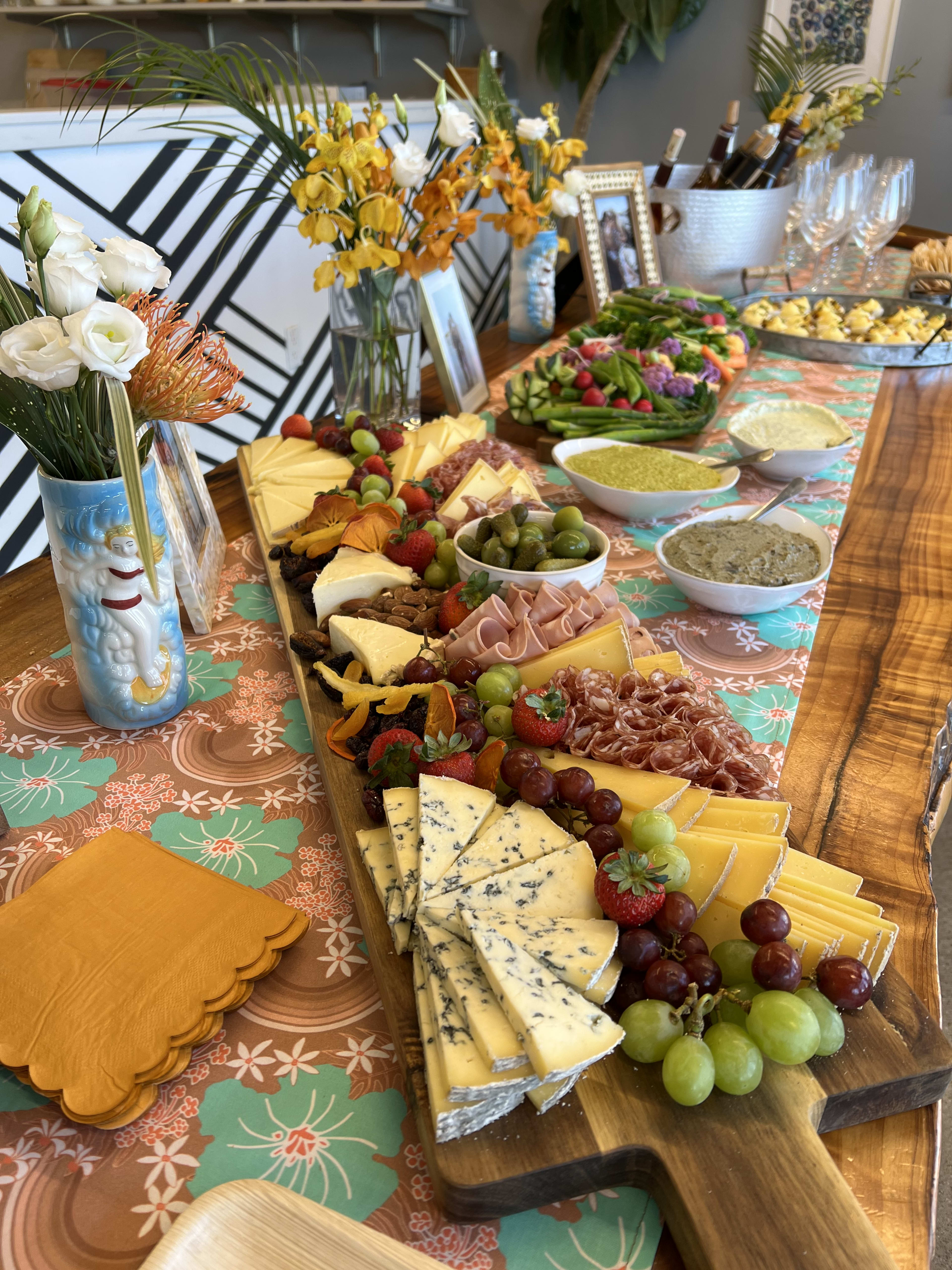 A baby shower table spread featuring a variety of cheeses and meats.