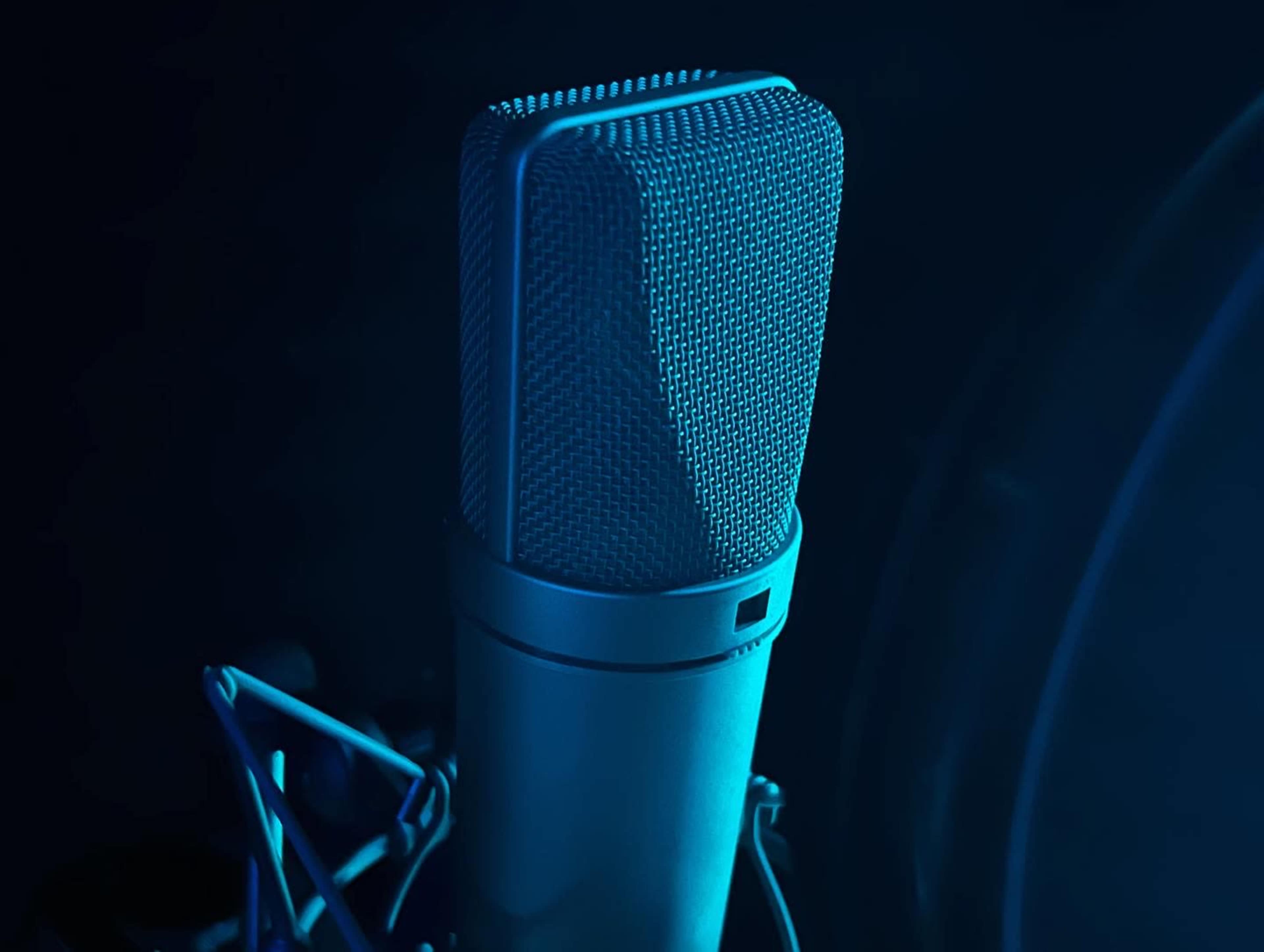 A close-up of a microphone with a mesh grille illuminated by blue lighting.