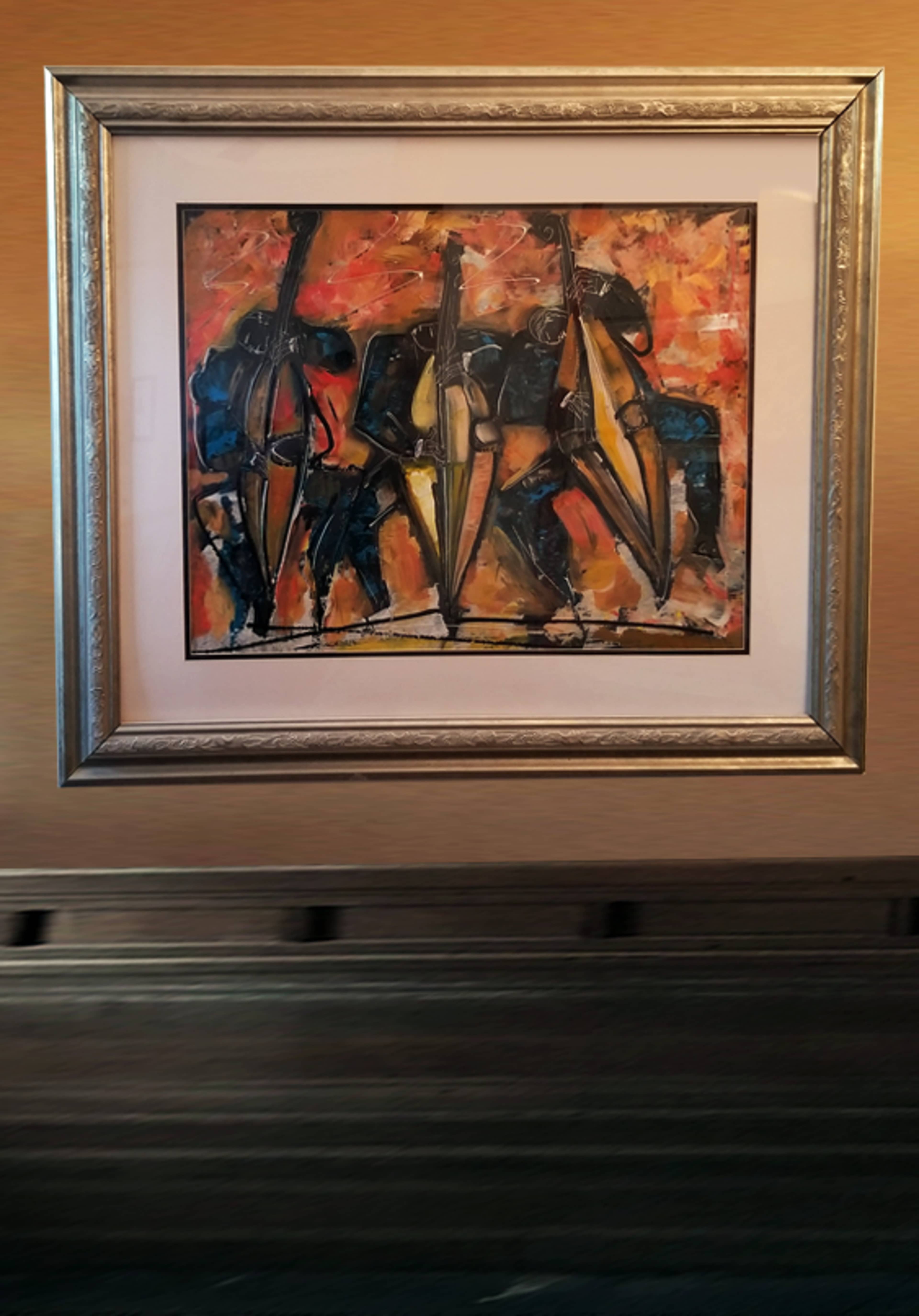 The image features a framed painting of three abstract figures holding large umbrellas against a warm, colorful background.
