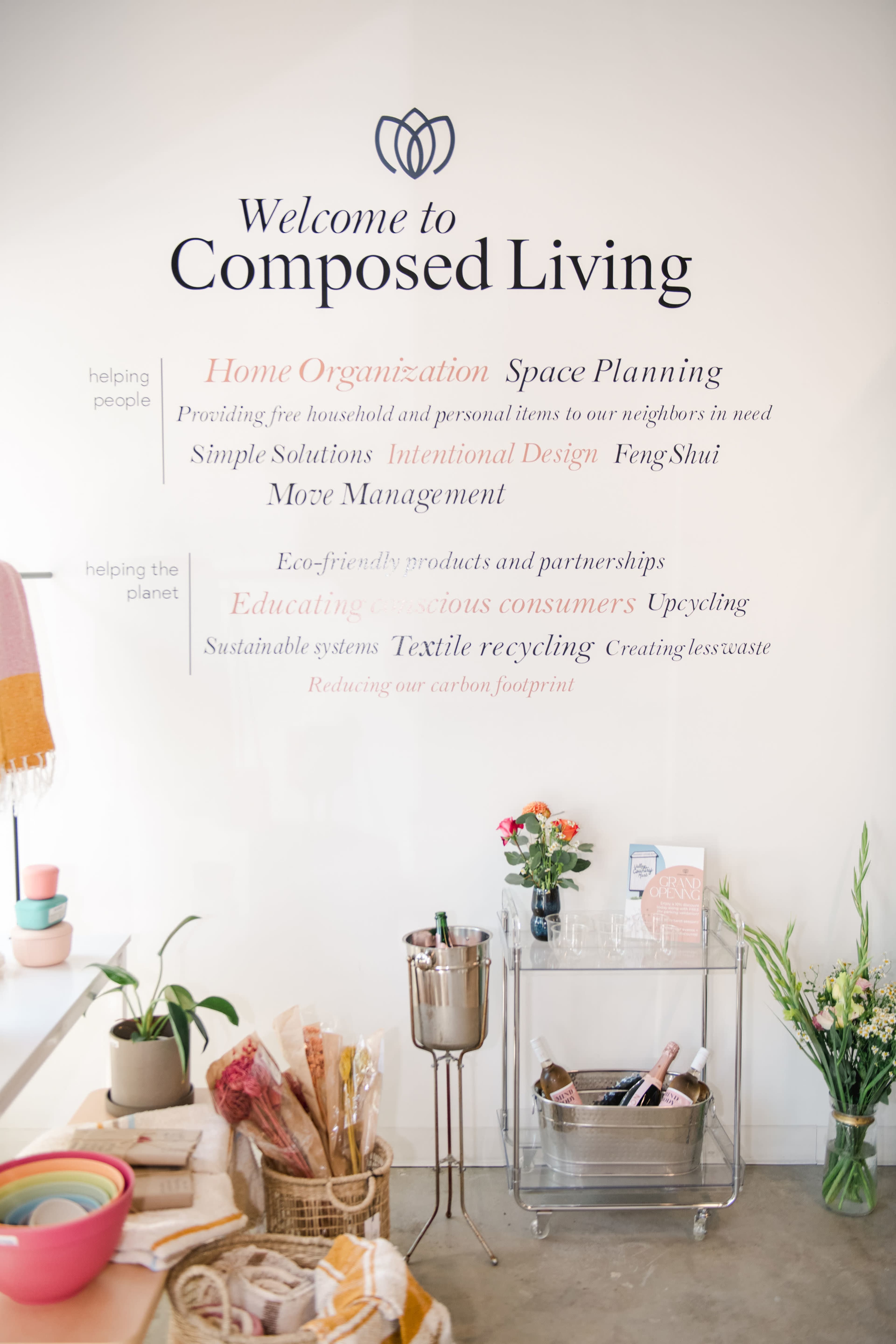 The wall features a welcoming message for "Composed Living," highlighting services such as home organization, space planning, and sustainability initiatives.