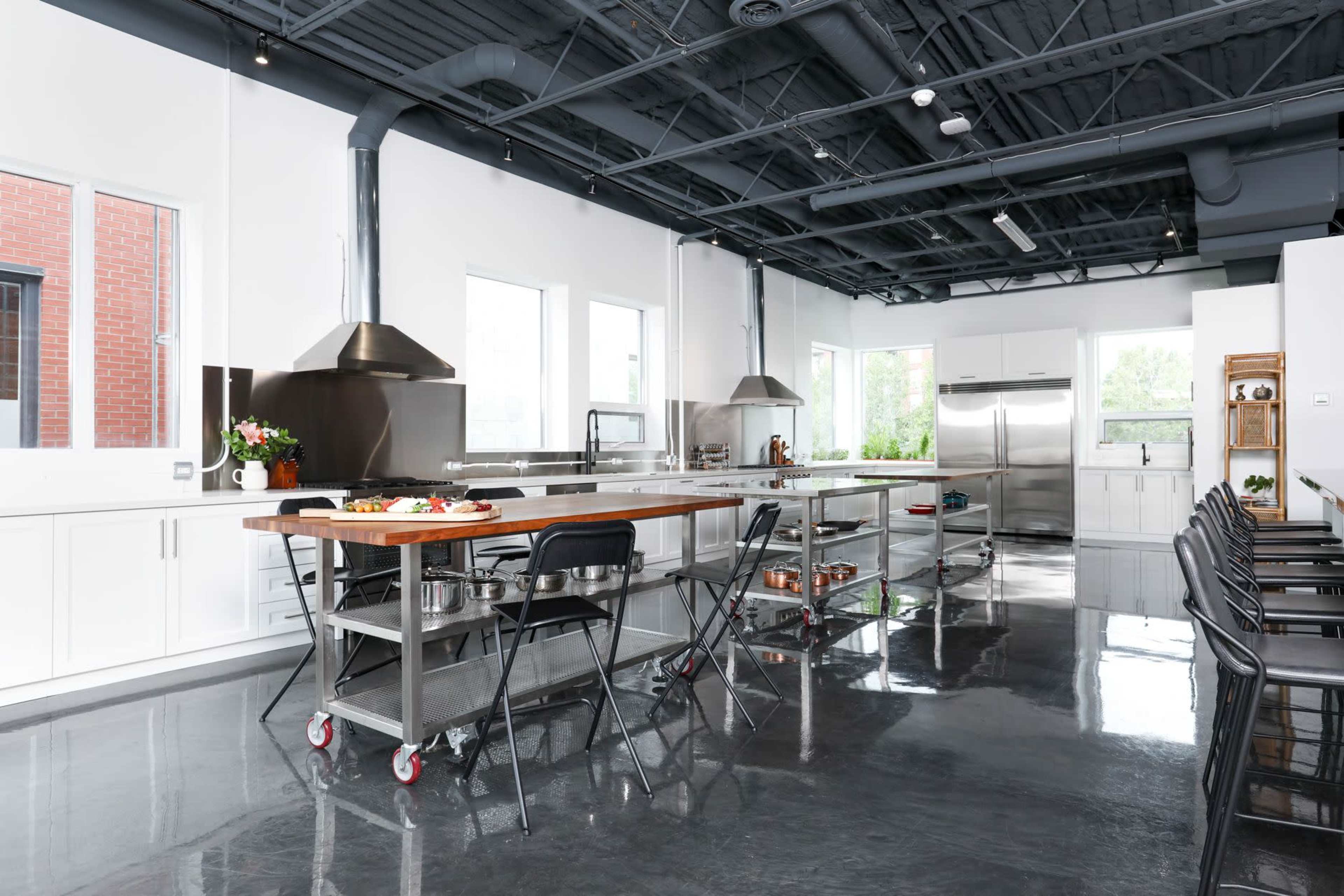 A modern kitchen with stainless steel appliances, a large central island, and multiple windows letting in natural light.