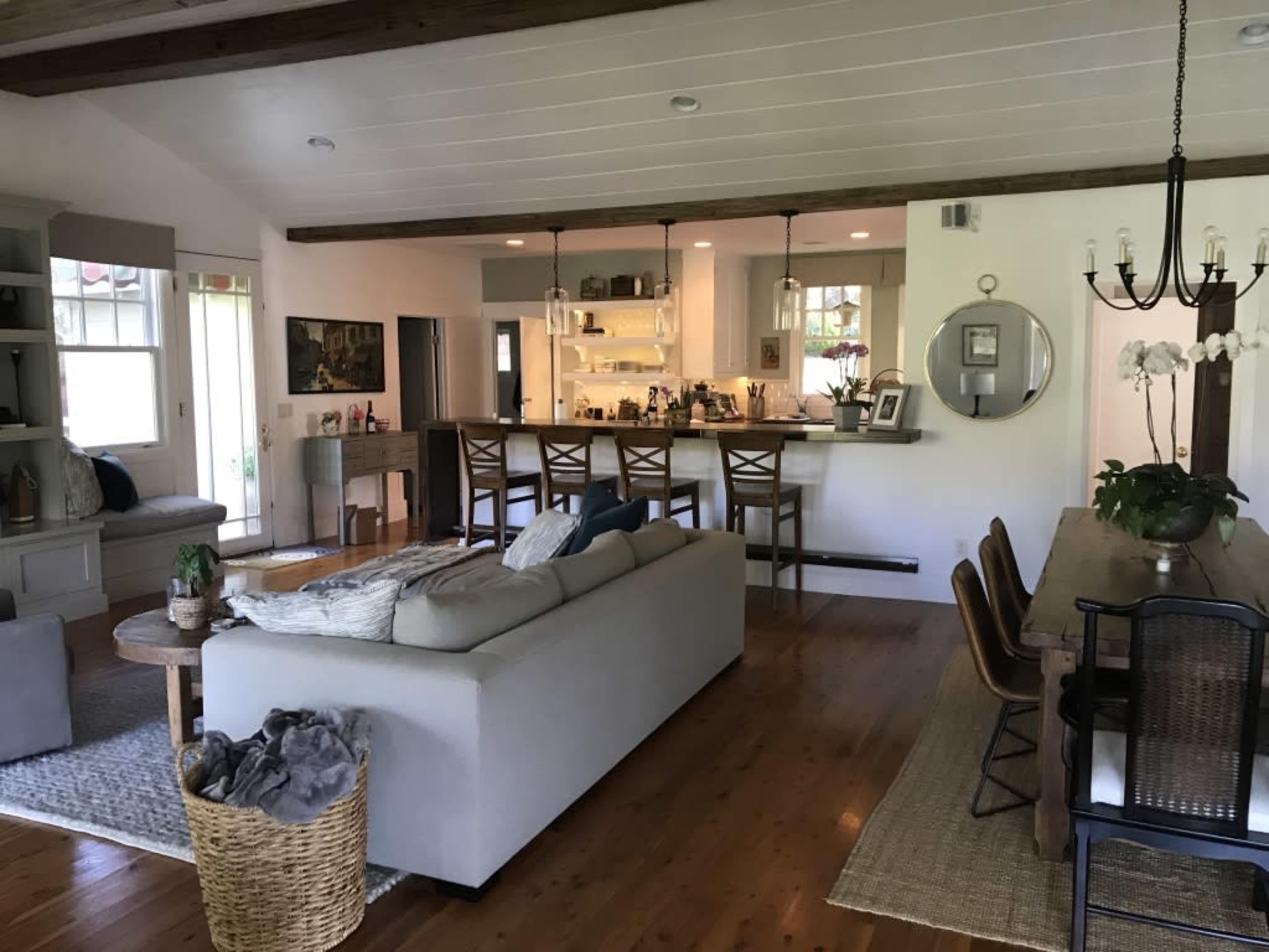 The image shows a spacious living area that features a kitchen, a dining table, and a comfortable seating arrangement.