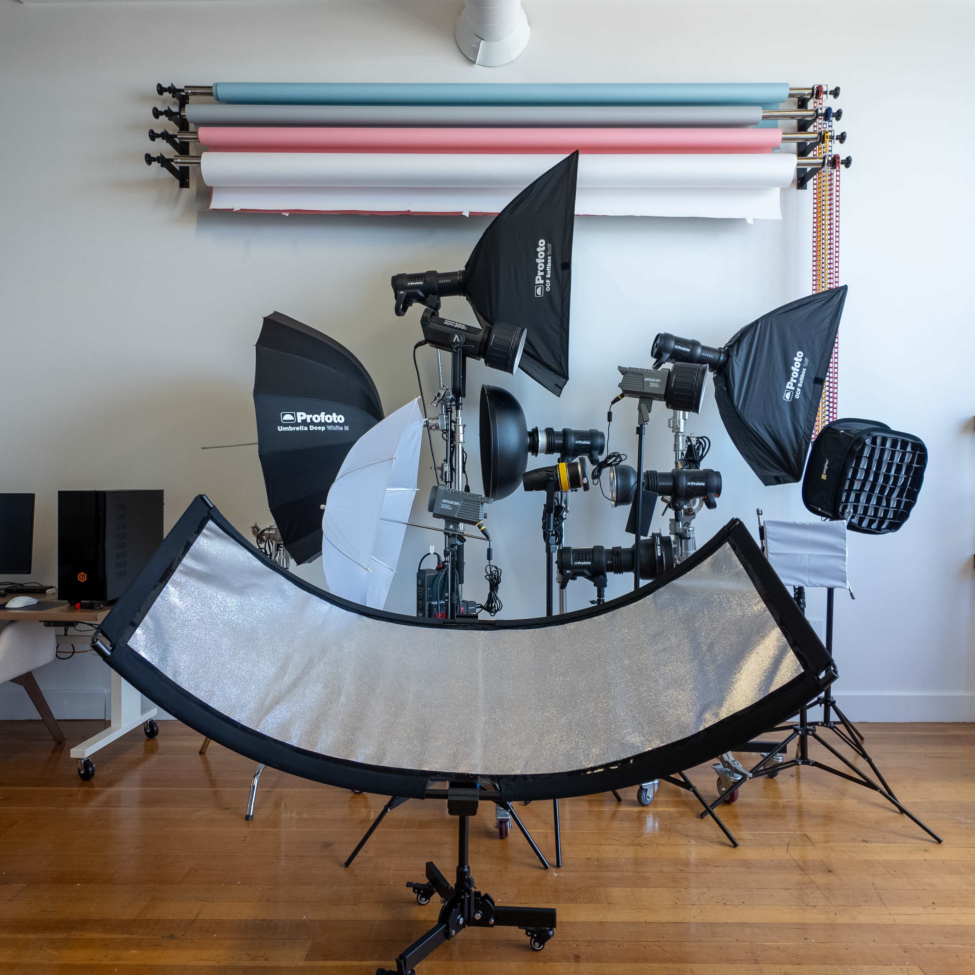 A photography studio setup with various lighting equipment, backdrops, and reflectors arranged in a well-organized space.