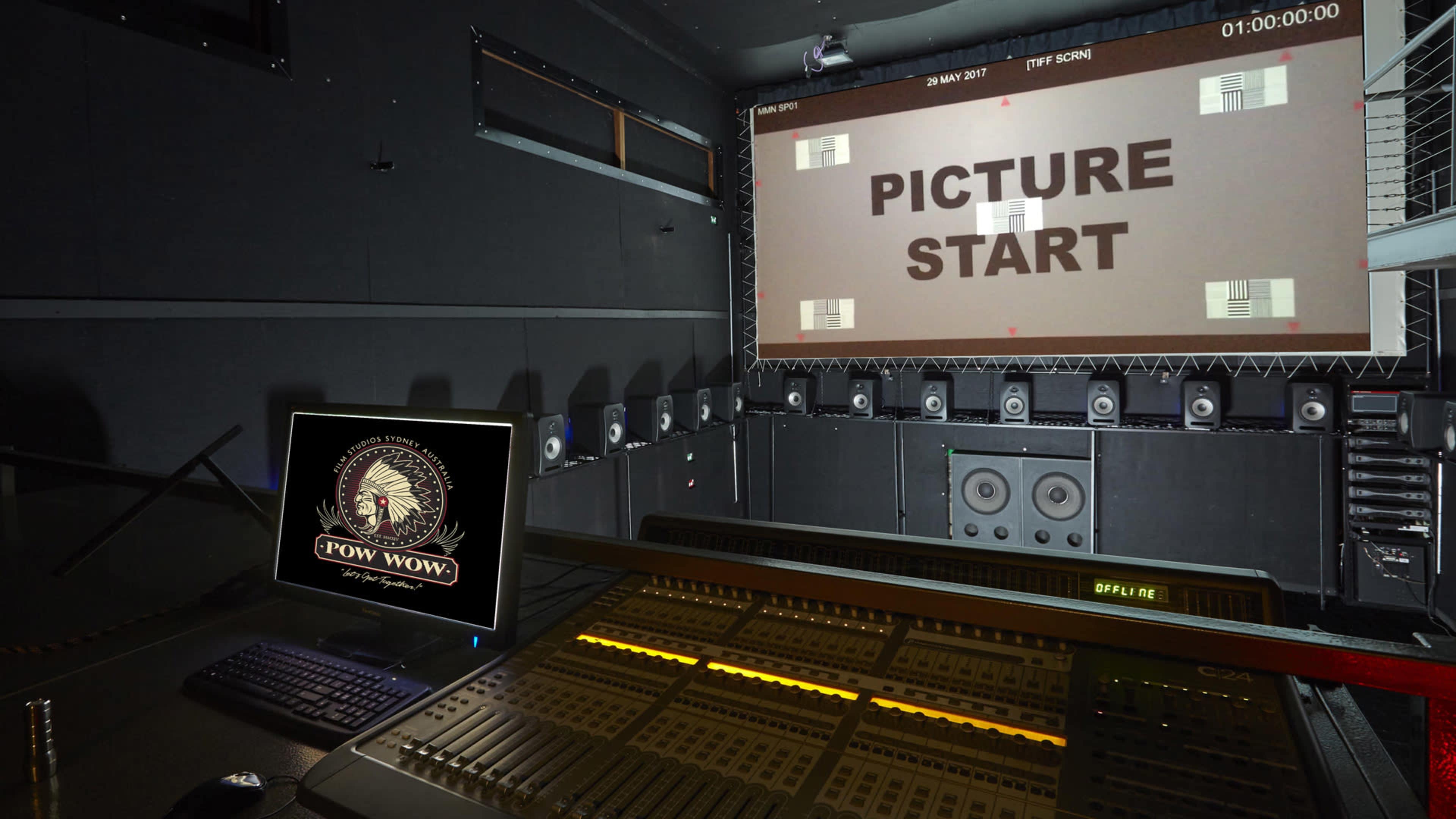 The image shows a sound studio with a large projection screen displaying "PICTURE START" and various speakers surrounding a control console.