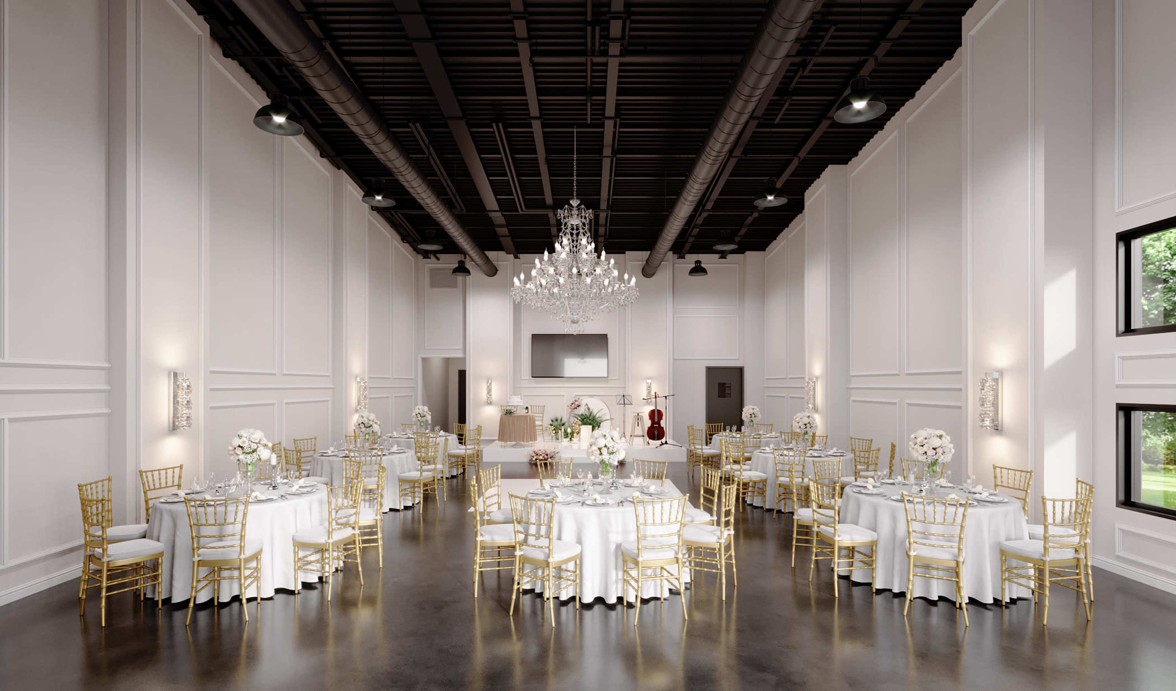 An elegantly decorated banquet hall with round tables set for a formal event, featuring white tablecloths and gold chairs, illuminated by a large chandelier.