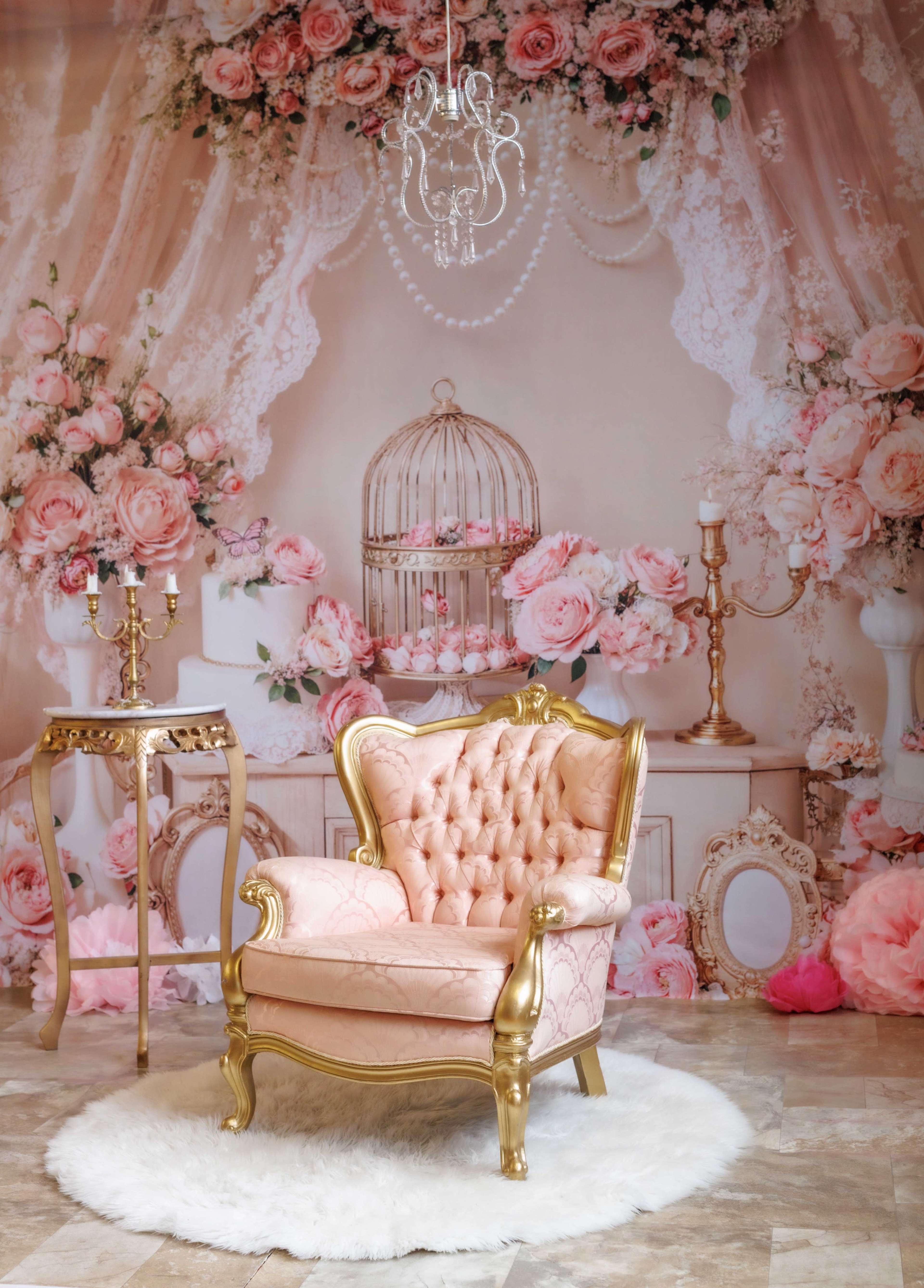 The image features a pink tufted armchair with golden accents set against a backdrop of floral decorations and elegant accessories.