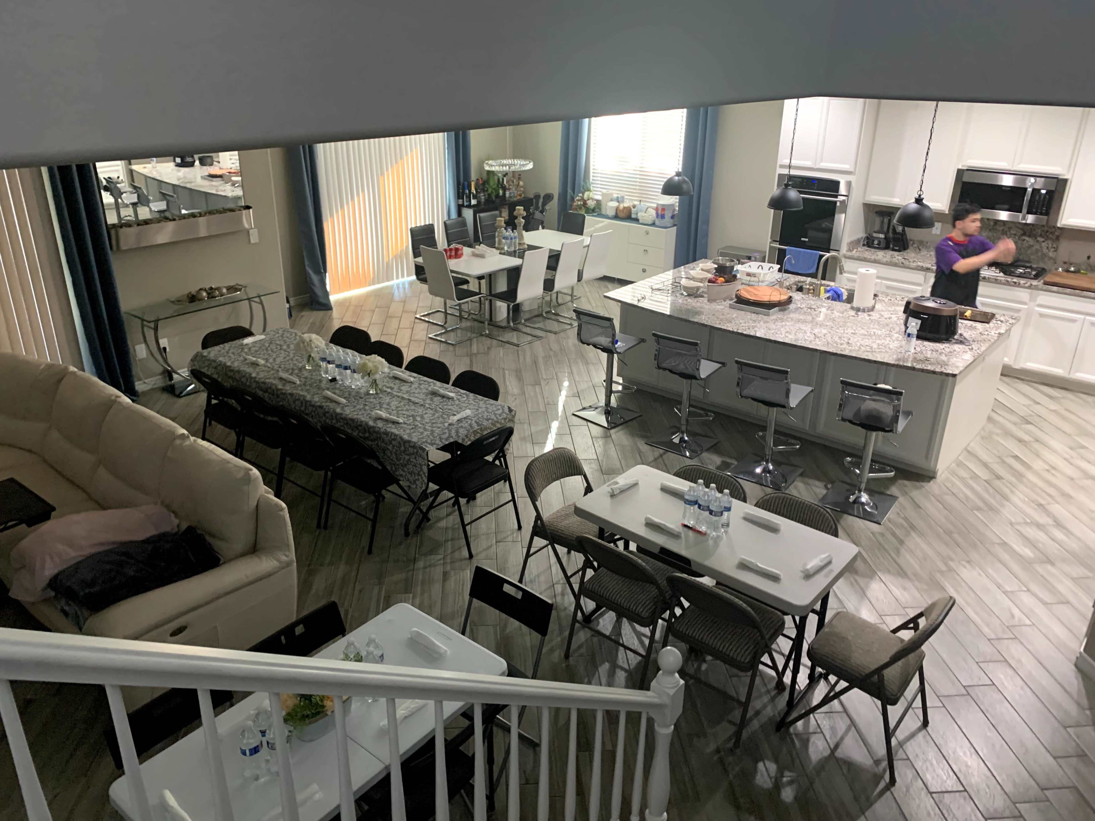 A spacious kitchen and dining area with a large table set for a gathering and seating at a kitchen island.