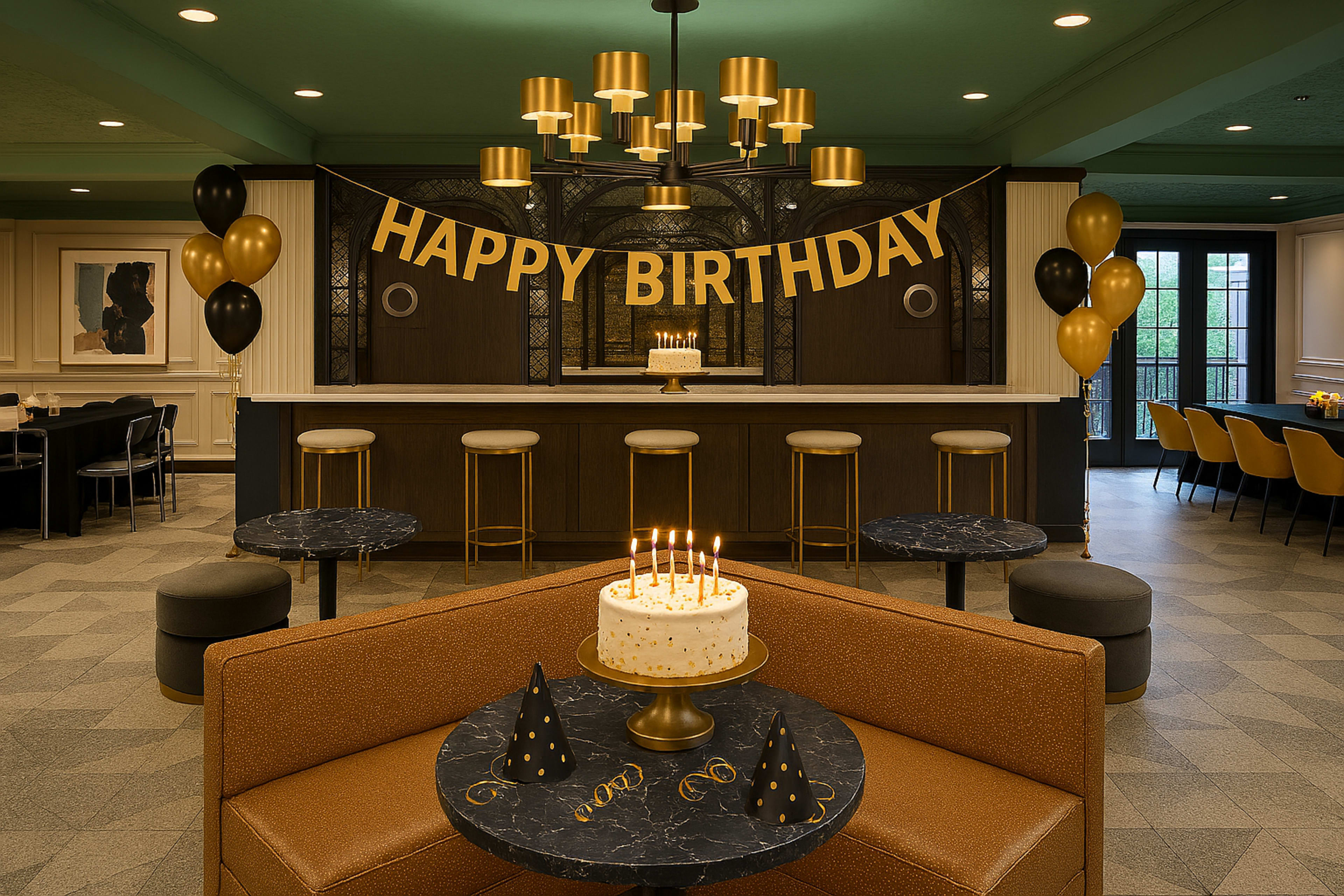 The image shows a decorated birthday party scene featuring a "Happy Birthday" banner, a cake with candles on a table, and black and gold party hats.