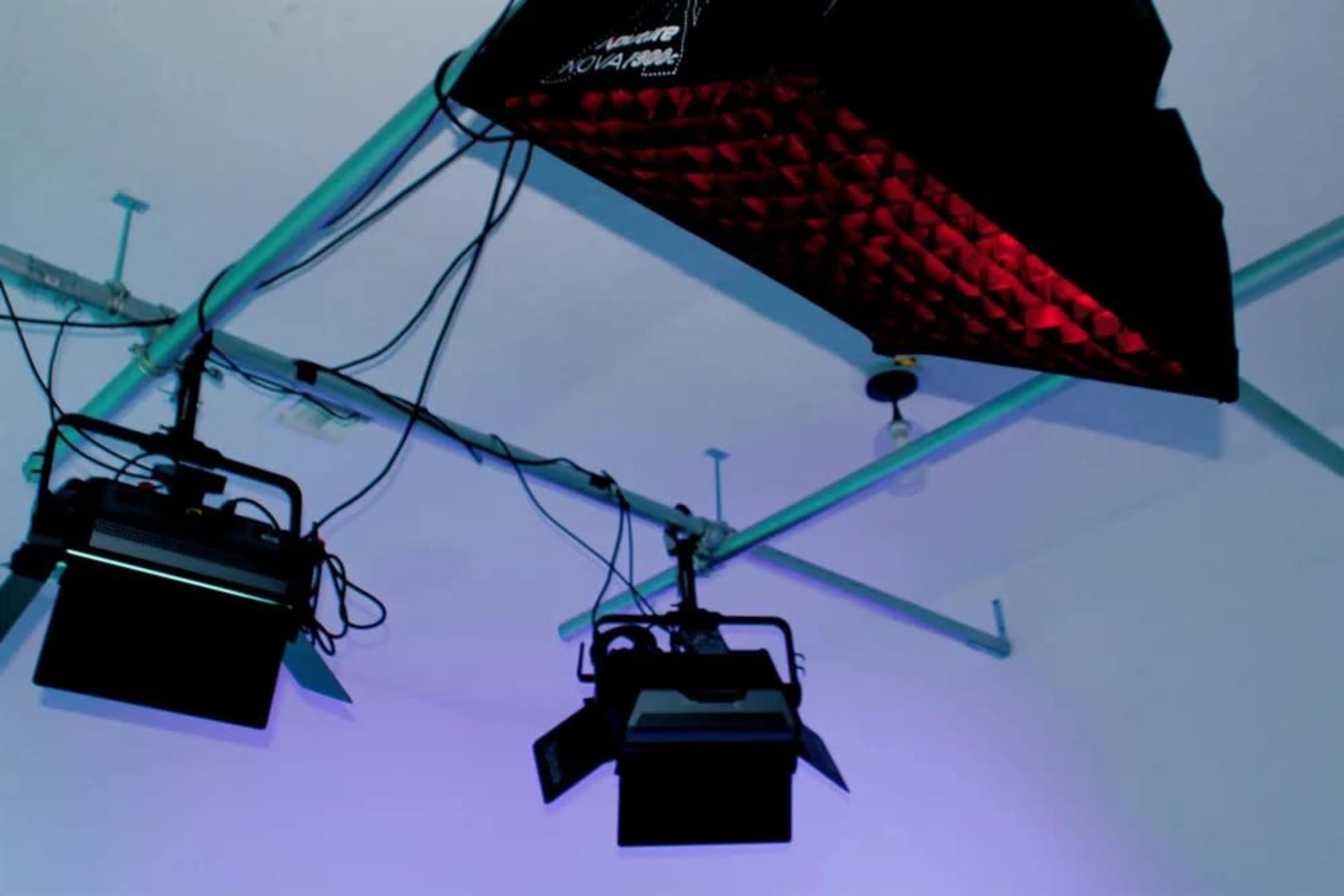 The image shows a ceiling-mounted lighting setup with multiple studio lights and a diffusing panel.
