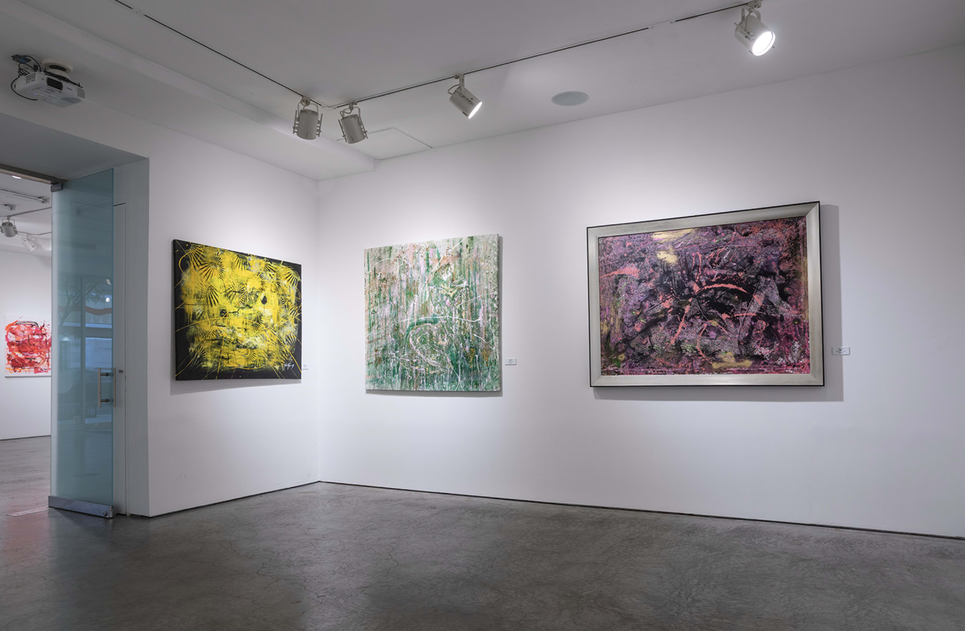 The image shows a gallery interior with four large abstract paintings displayed on white walls.