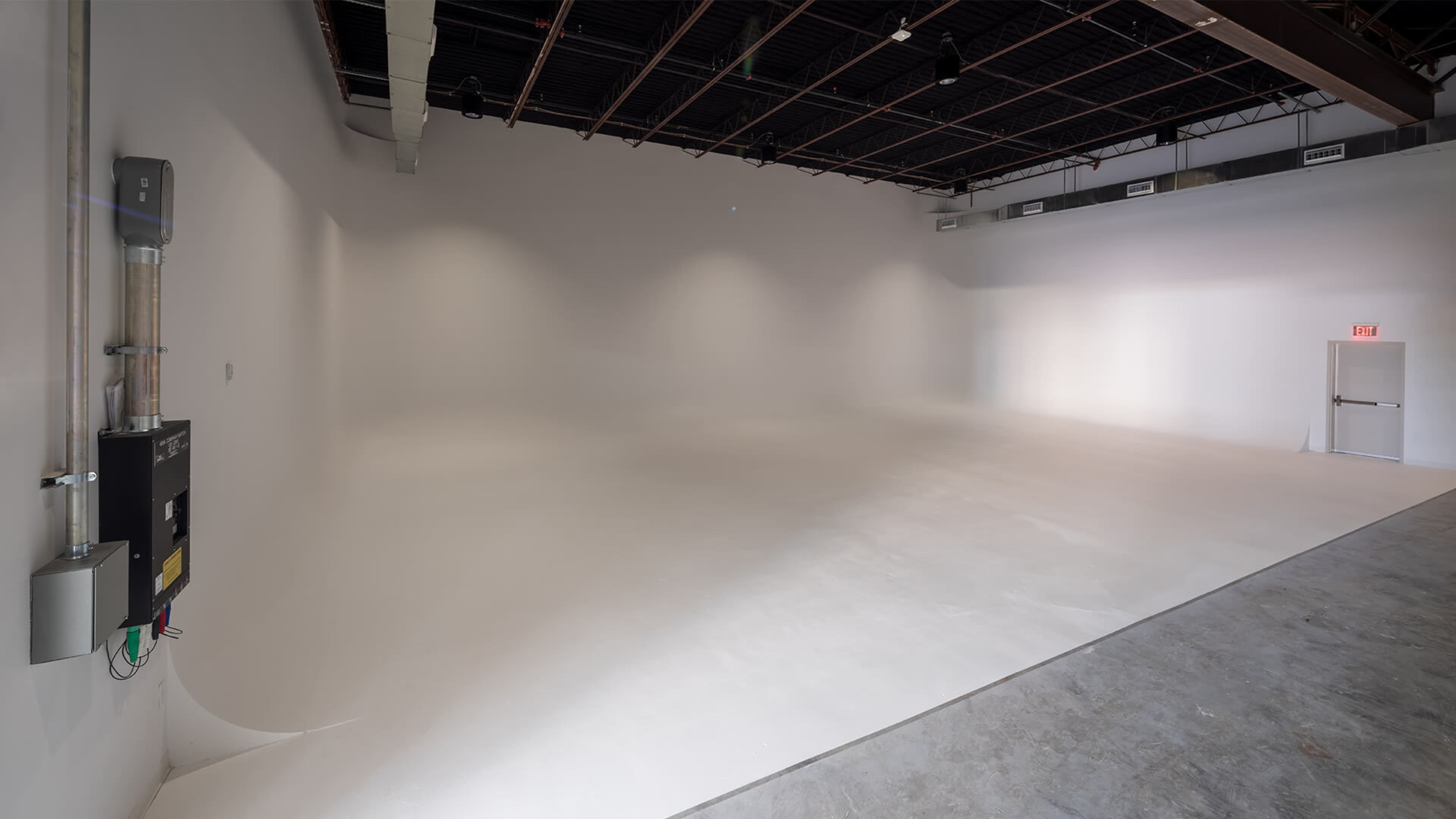 A spacious, empty studio with white walls and a smooth, light-colored floor.