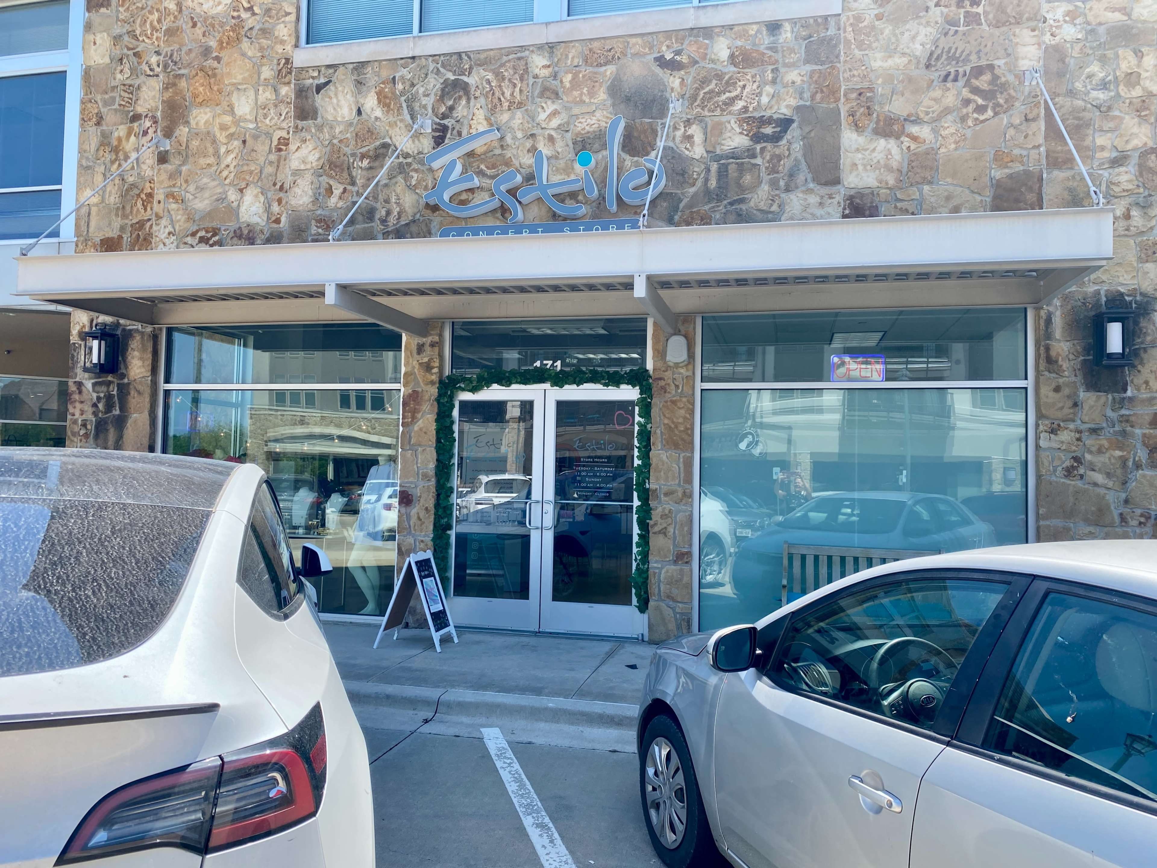 The entrance of a business named "Fertile" with a stone exterior and parked cars in front.