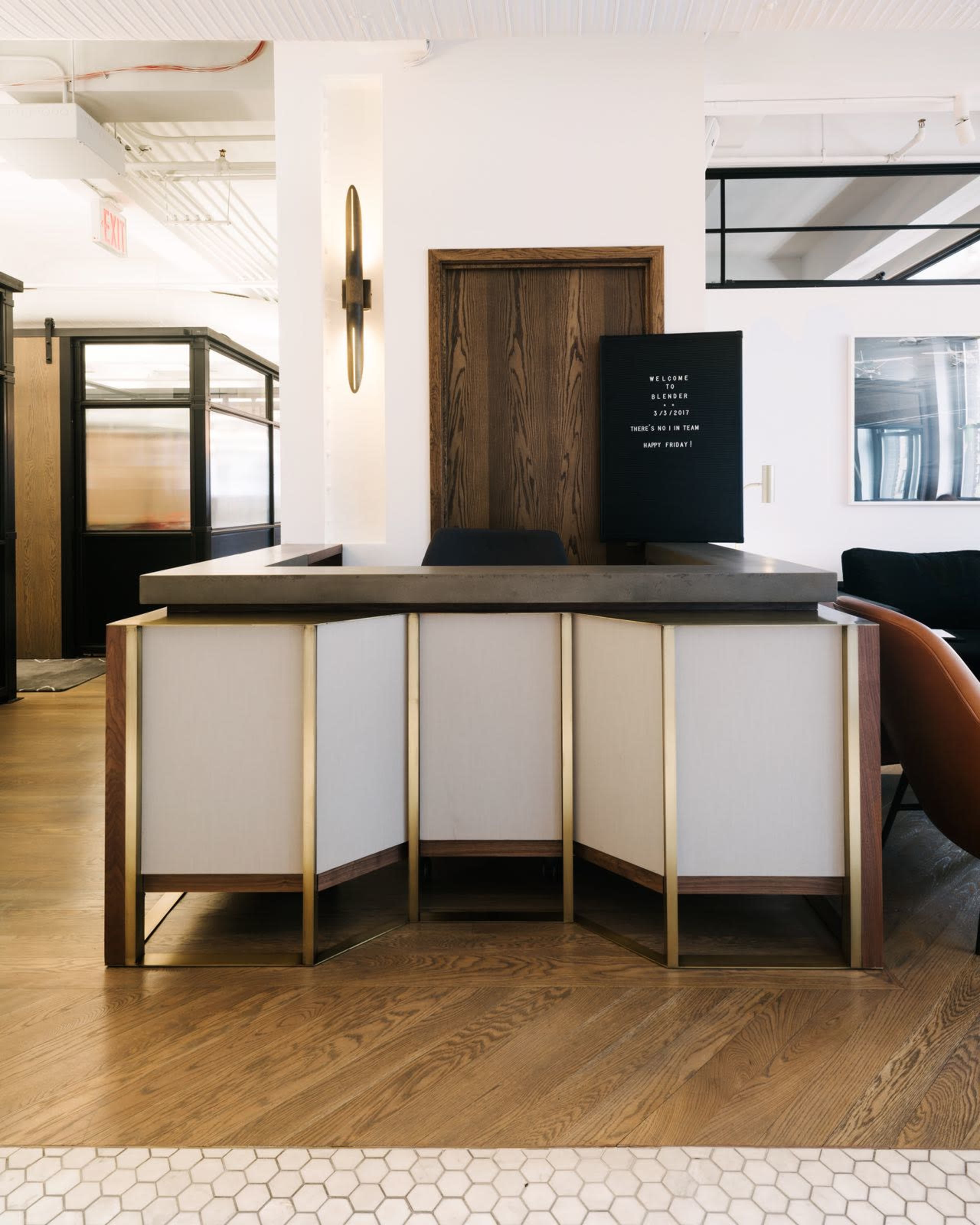 The image shows a modern reception desk with a sleek design in a well-lit office space.