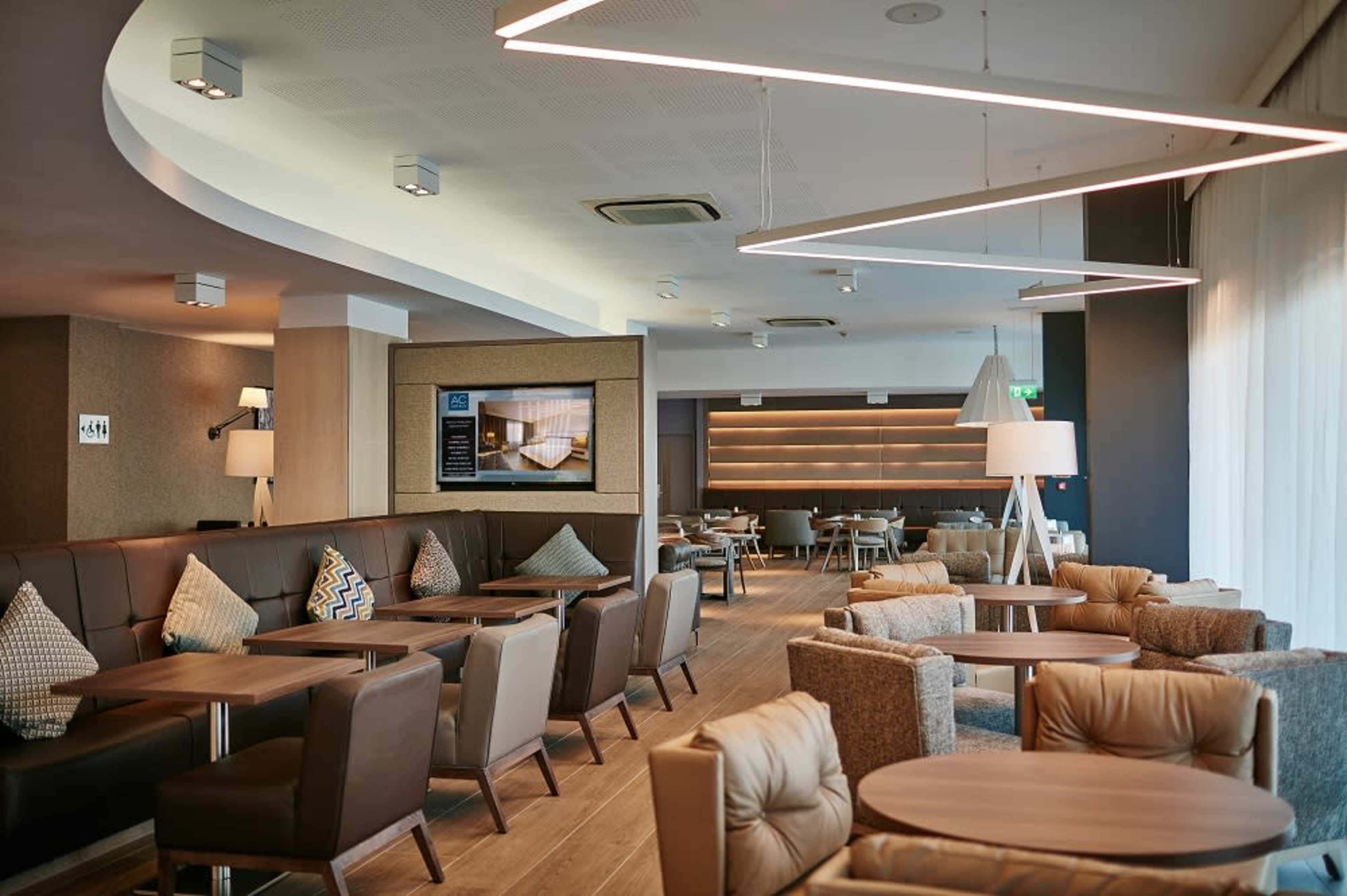 A modern lounge area with wooden floors, contemporary furniture, and soft lighting, designed for relaxation and socializing.