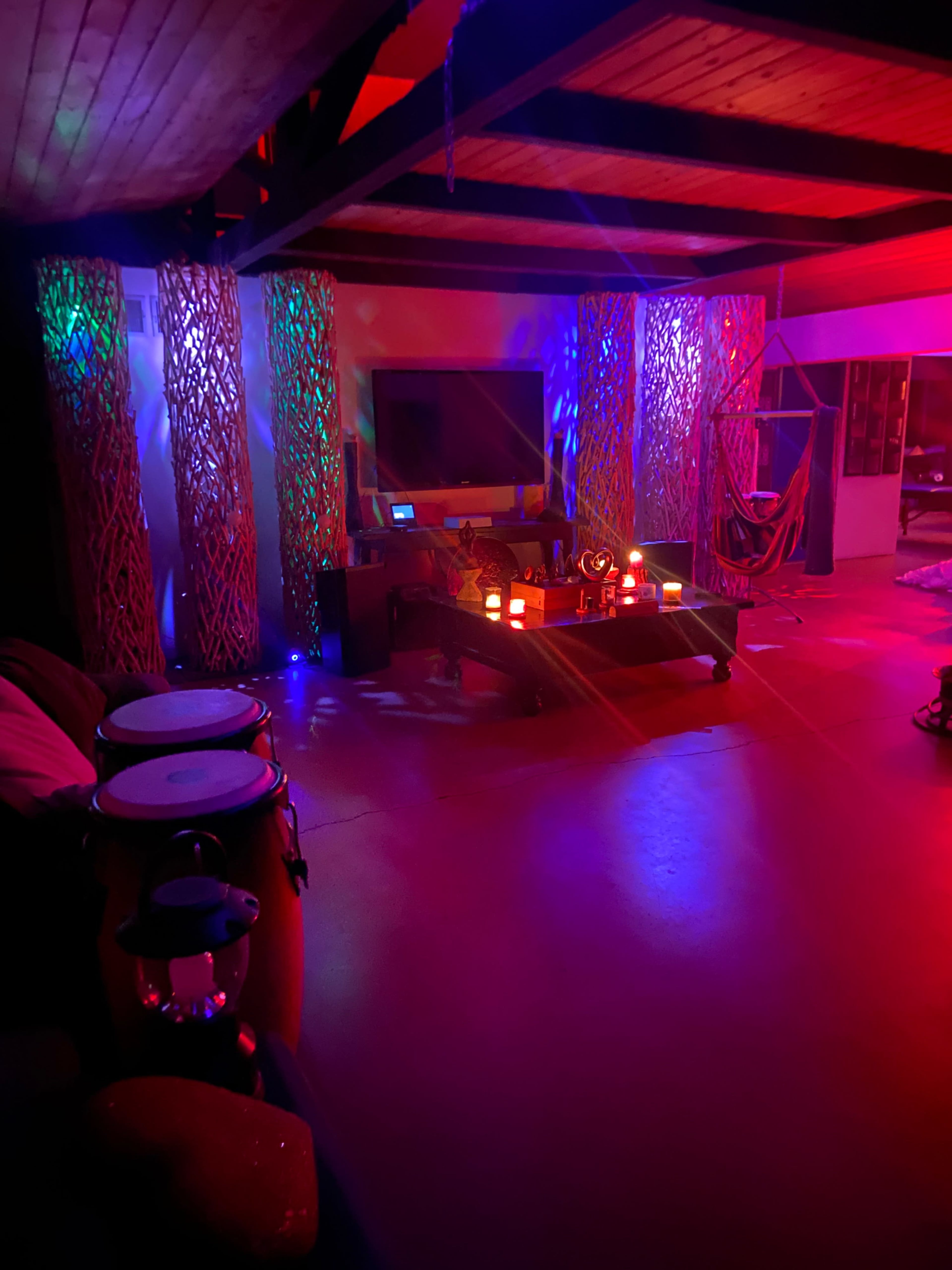 The scene features a dimly lit room with colorful lighting effects, decorated with illuminated panels and musical instruments displayed.