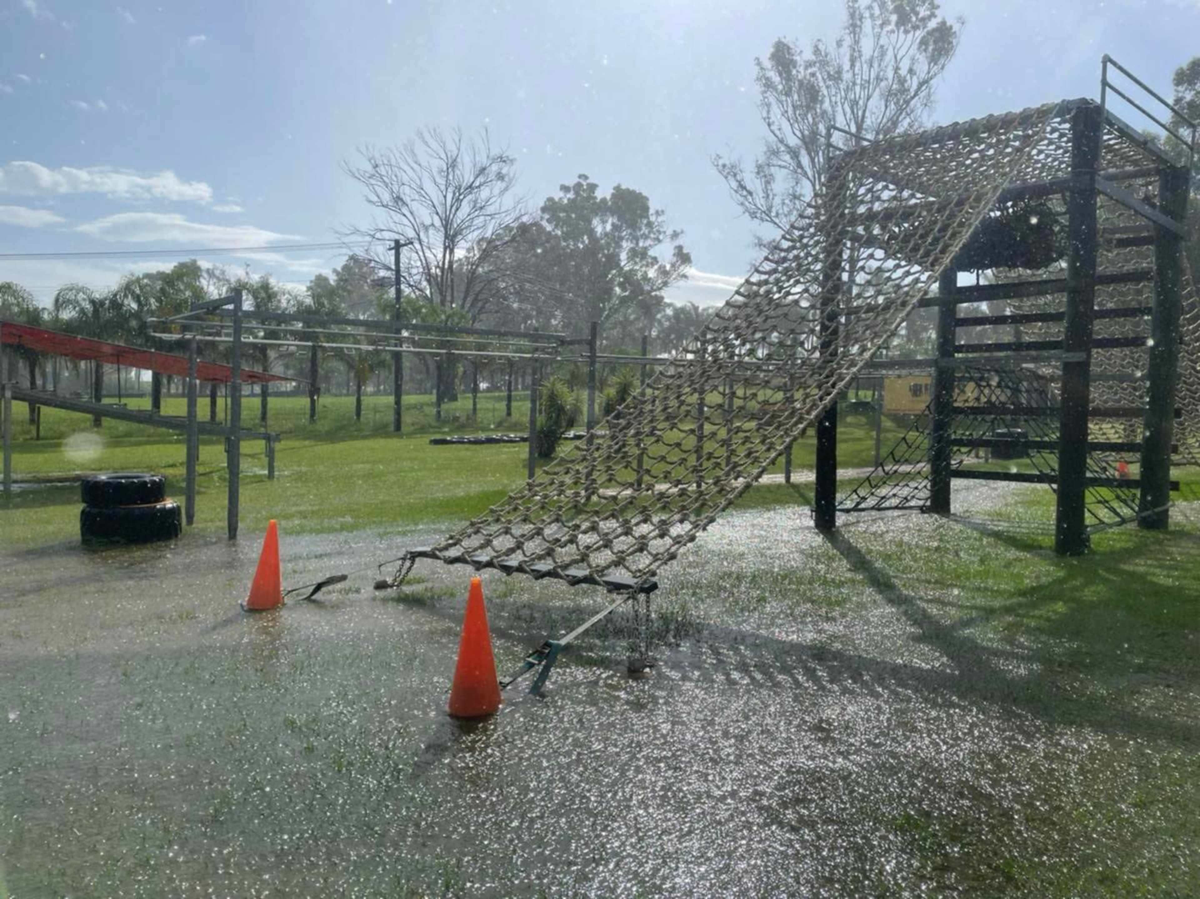 A playground obstacle course is partially submerged in water on a rainy day.