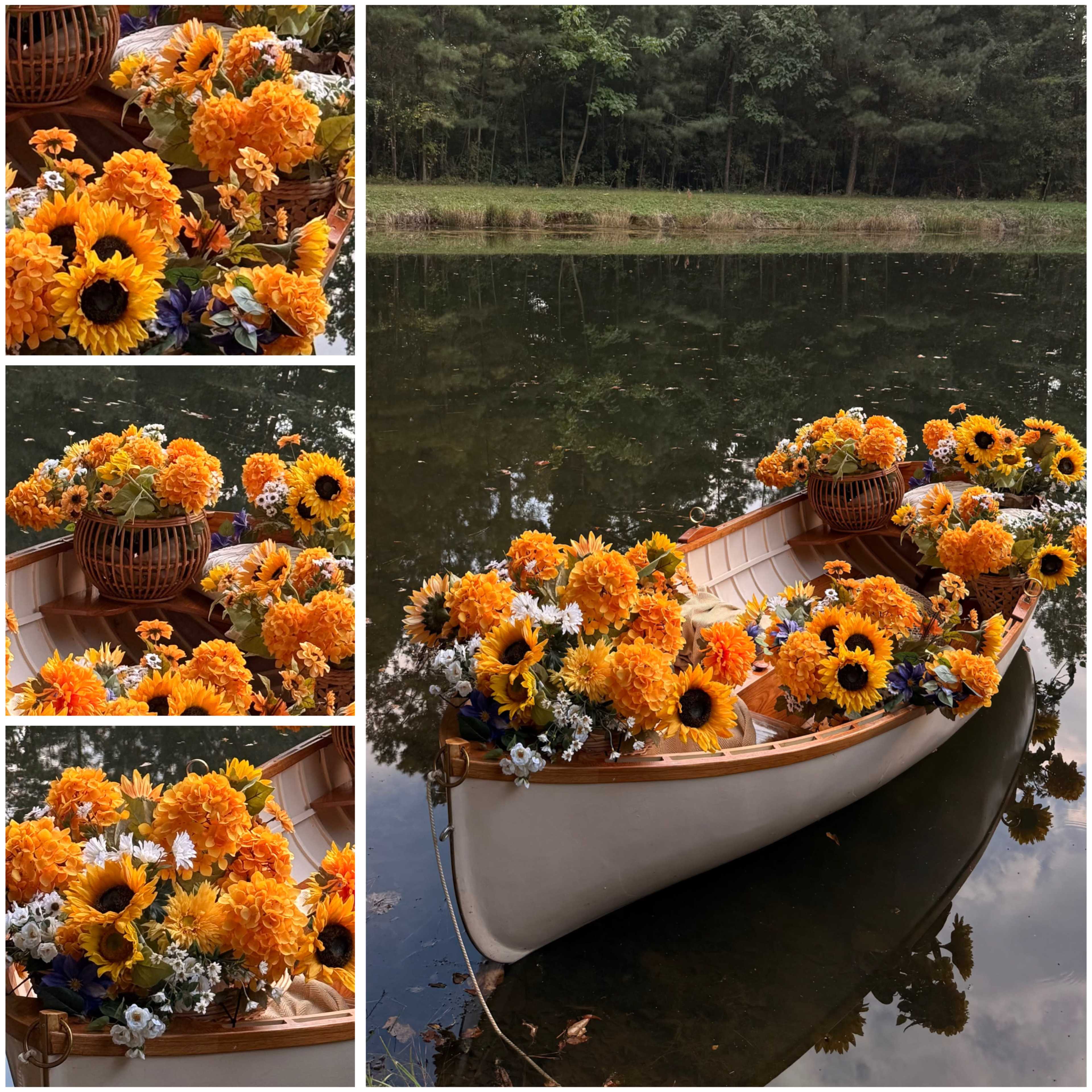 A white rowboat filled with vibrant sunflowers and other flowers is floating on a calm pond surrounded by trees.