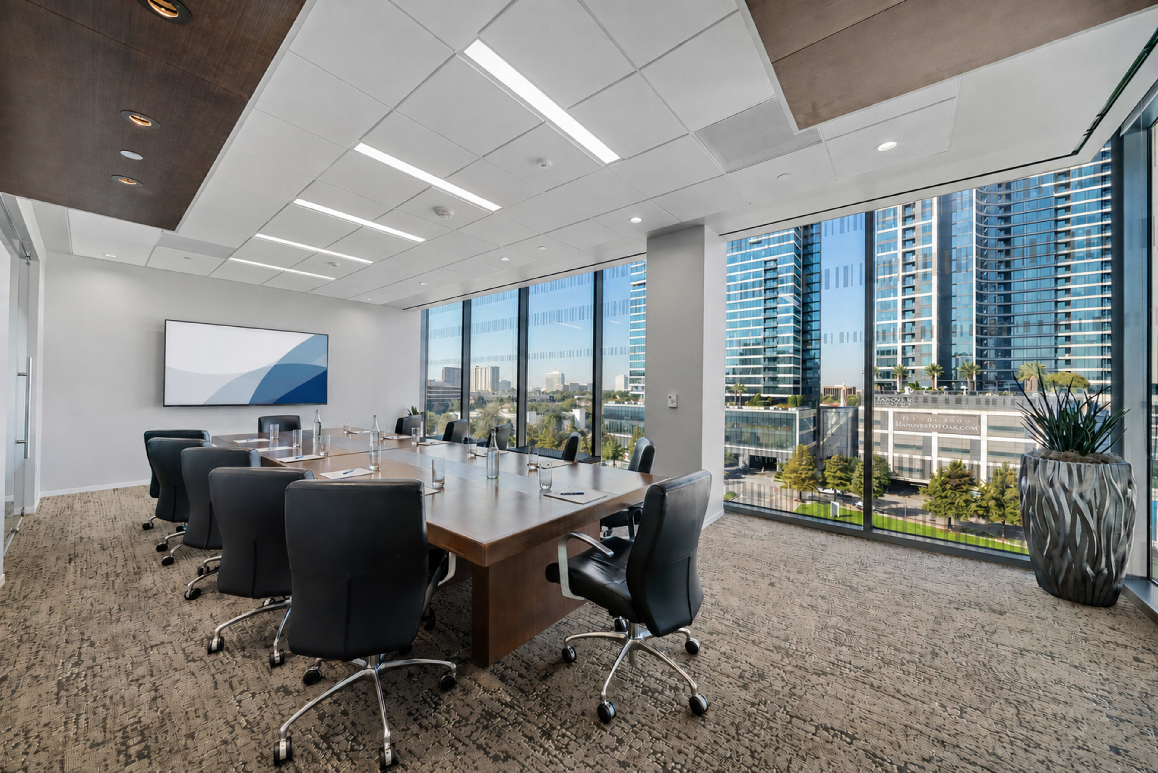 A modern conference room features a large wooden table surrounded by black chairs, with floor-to-ceiling windows overlooking a cityscape.