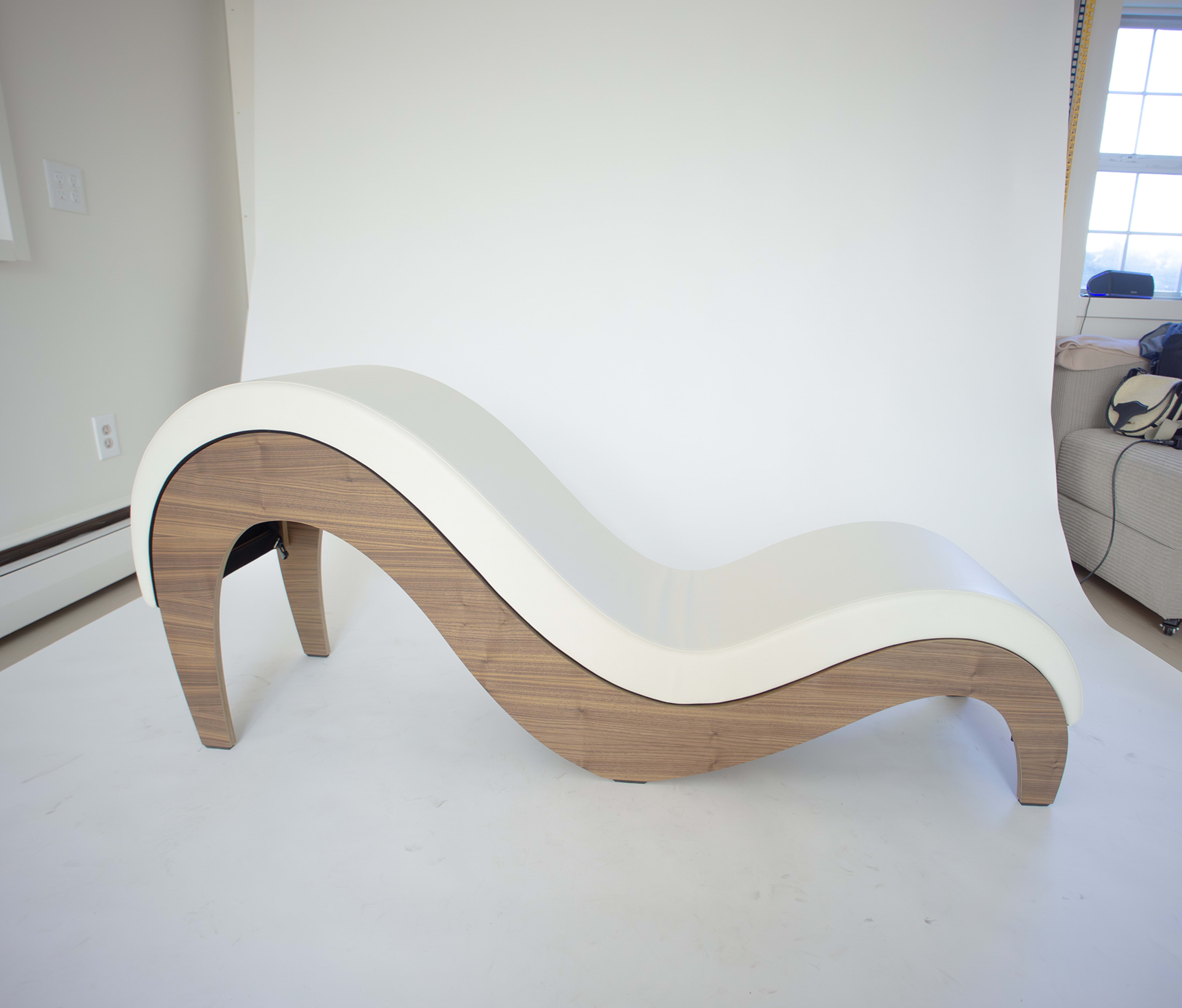 The image features a modern, curved lounge chair with a white upholstery top and wooden base.
