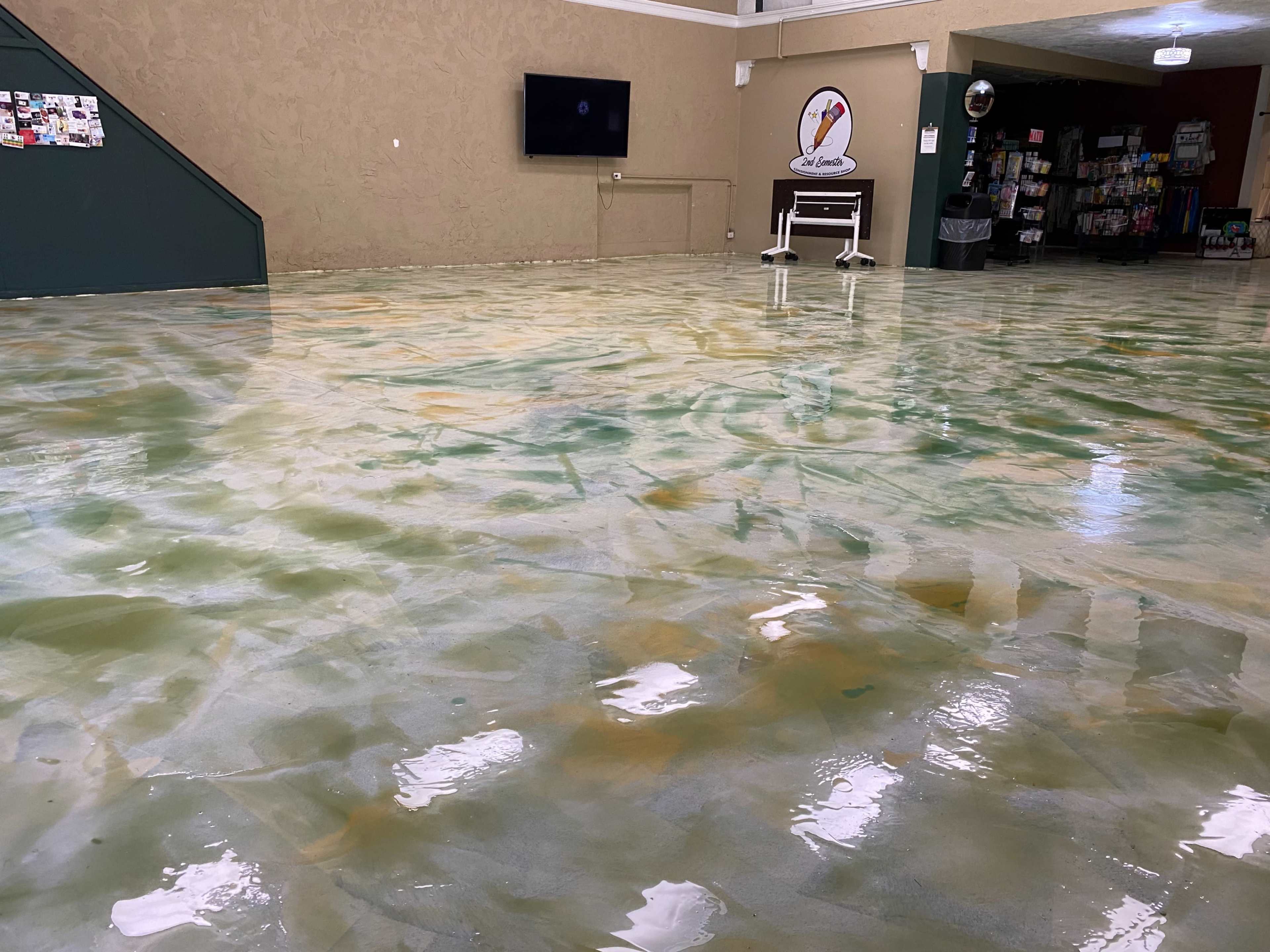 The scene shows a spacious indoor area with a glossy, multi-colored floor and a television mounted on the wall.