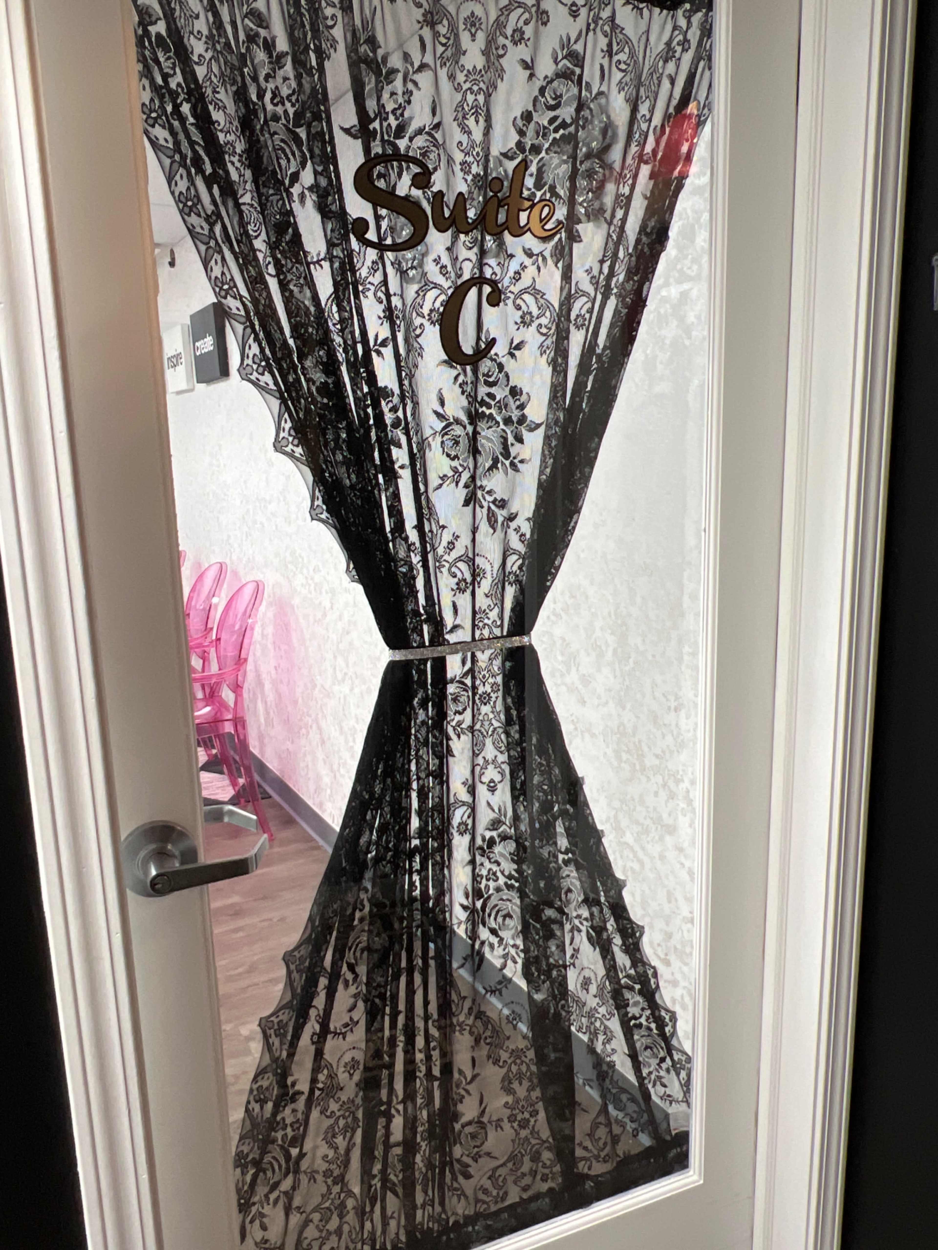 The image shows a door with a lace curtain and the label "Suite C" affixed to it.