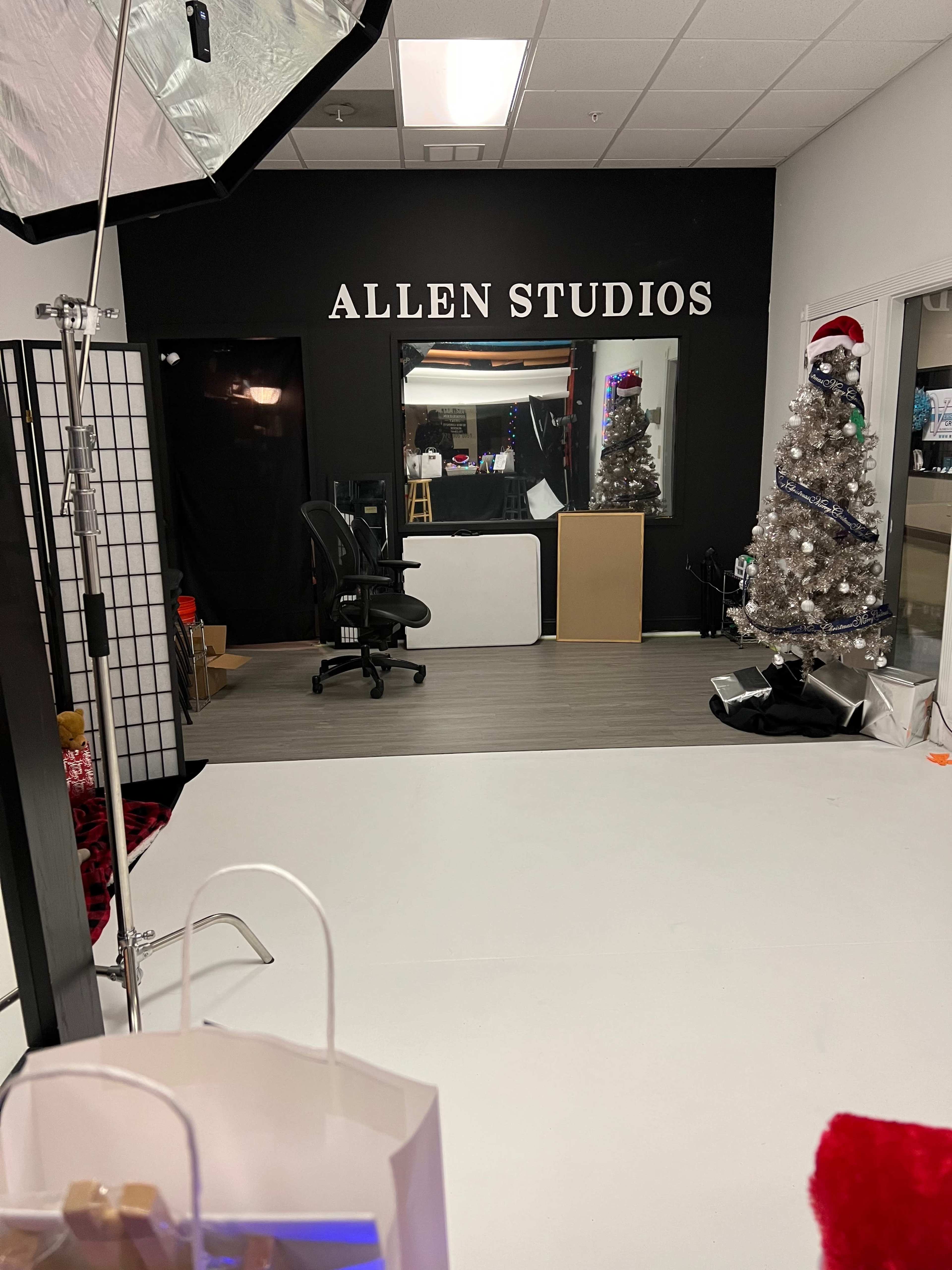 The interior of a studio labeled "ALLEN STUDIOS," featuring a white floor, a Christmas tree, and a mirrored wall with various items and furniture.