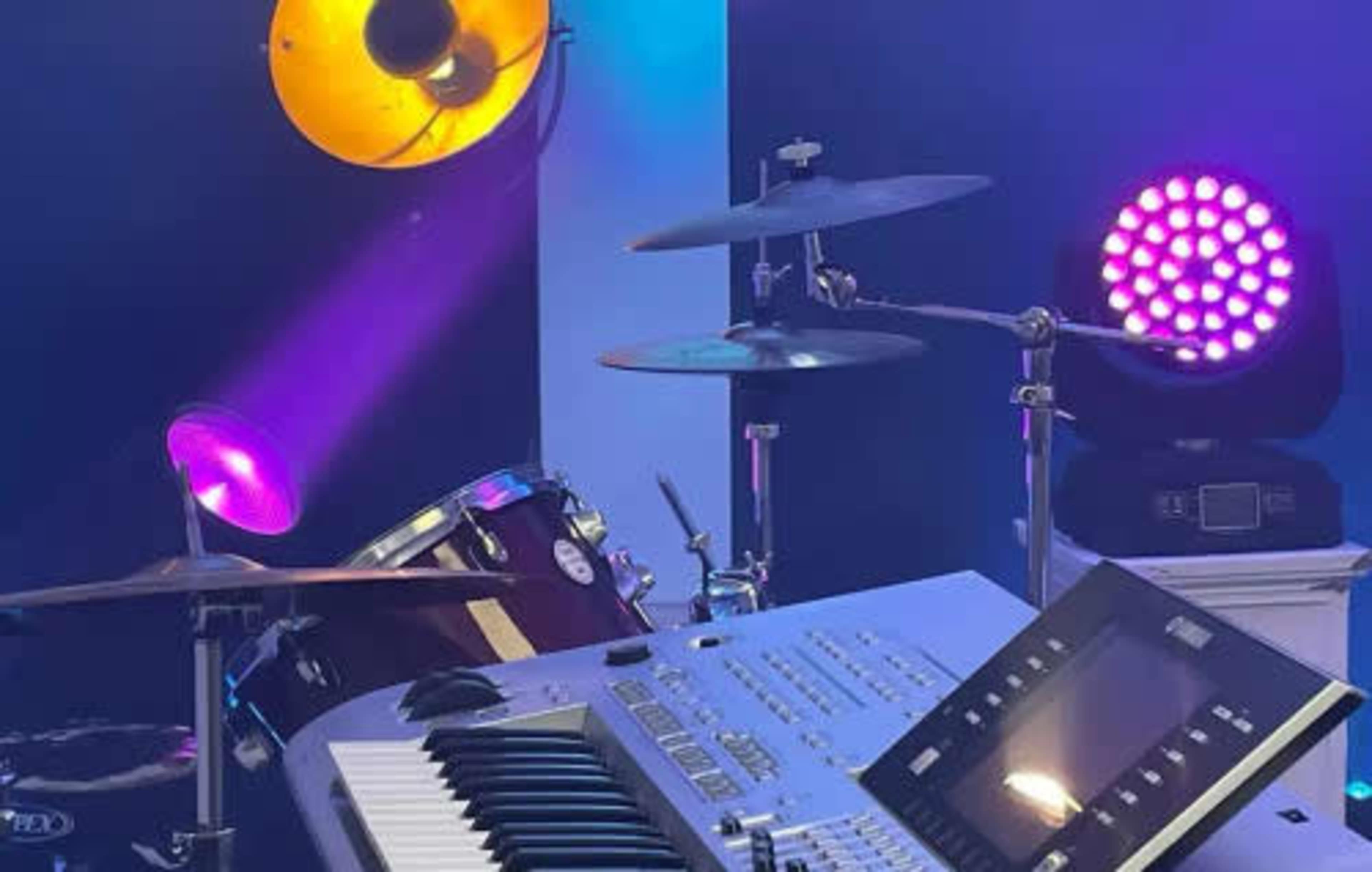 A music setup featuring a drum kit, a keyboard, and colorful stage lighting.
