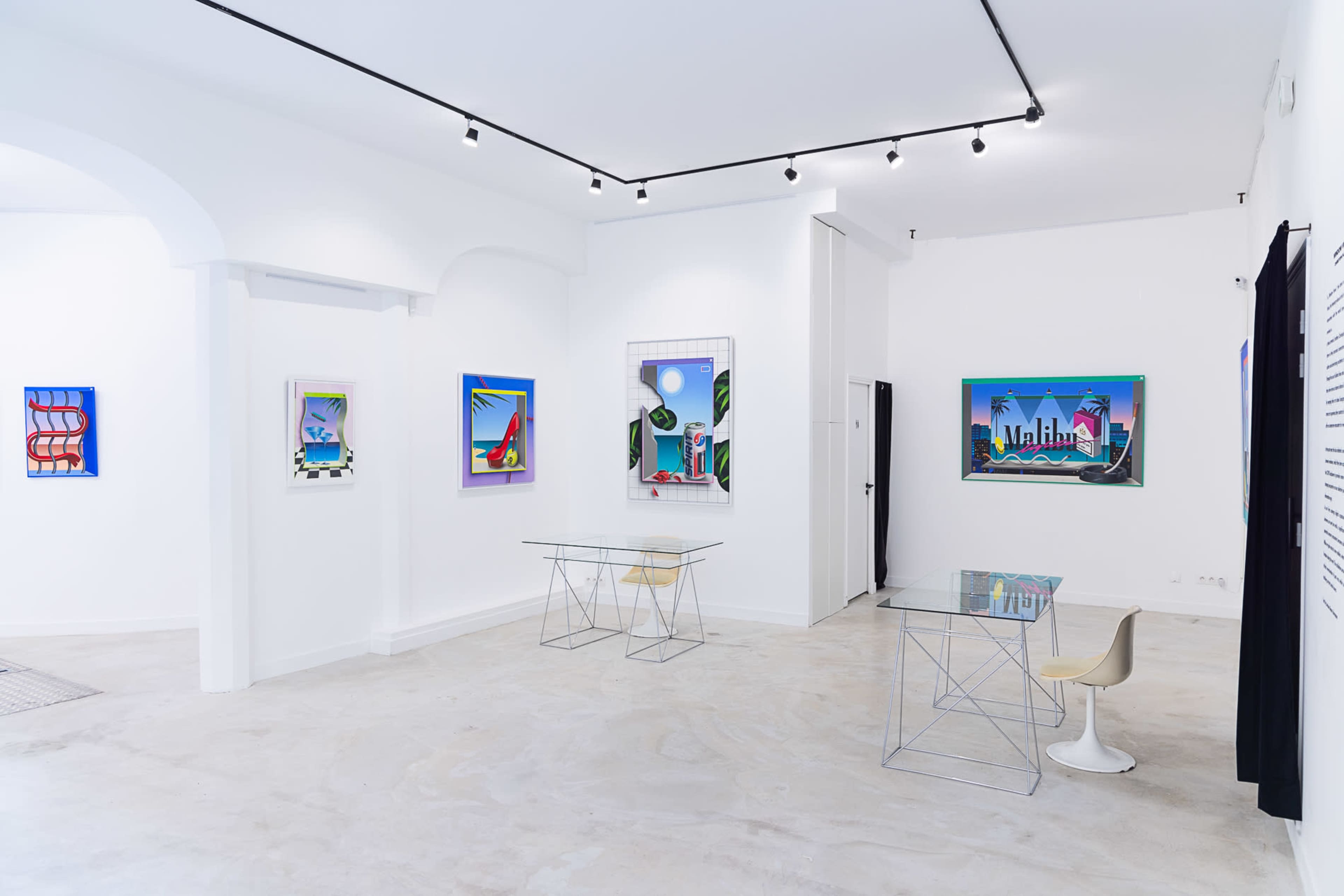A modern art gallery with white walls, featuring colorful artwork and minimalistic furniture.