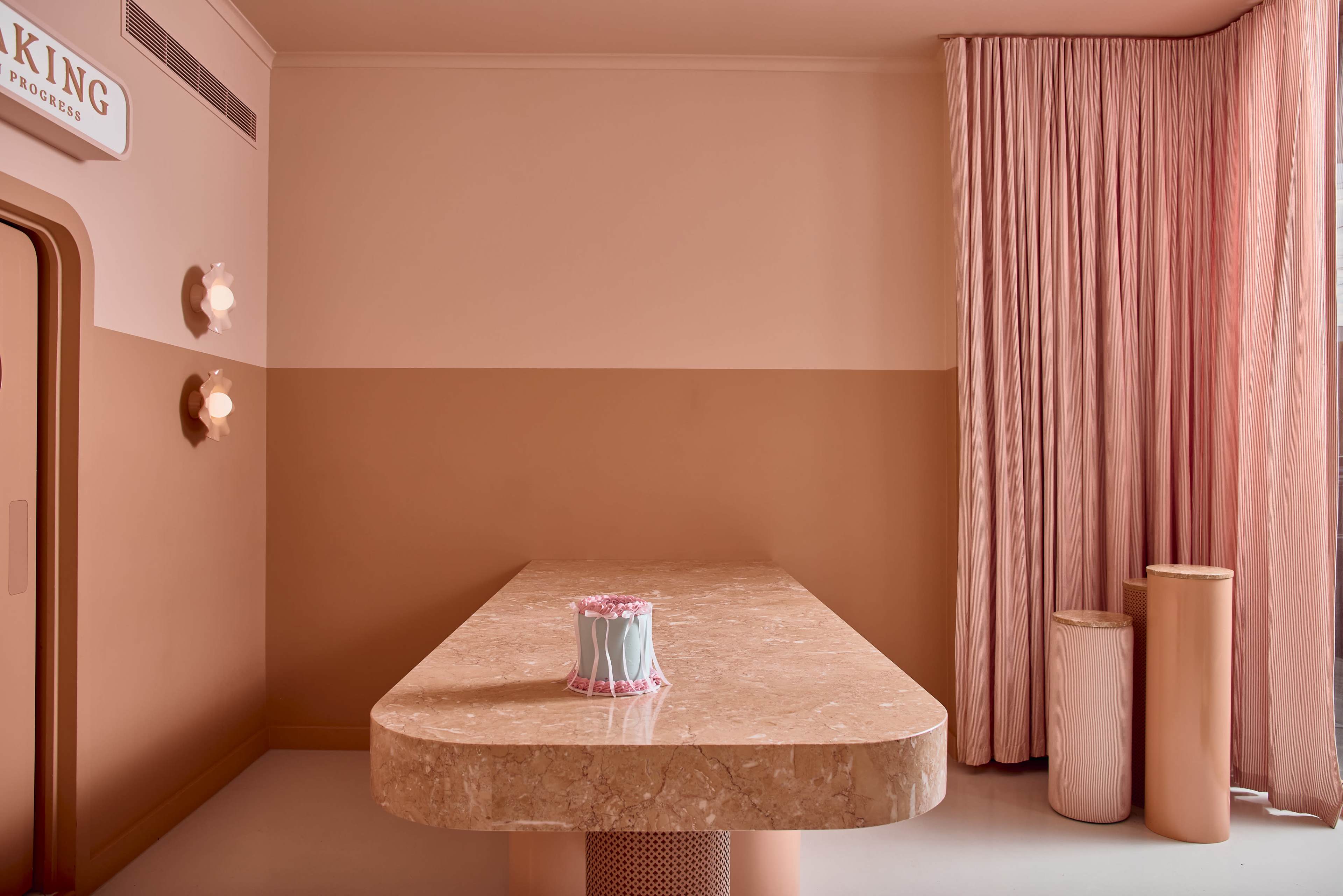 The image depicts a modern interior featuring a marble table, pale pink walls, and a curtain, with minimalistic lighting fixtures.
