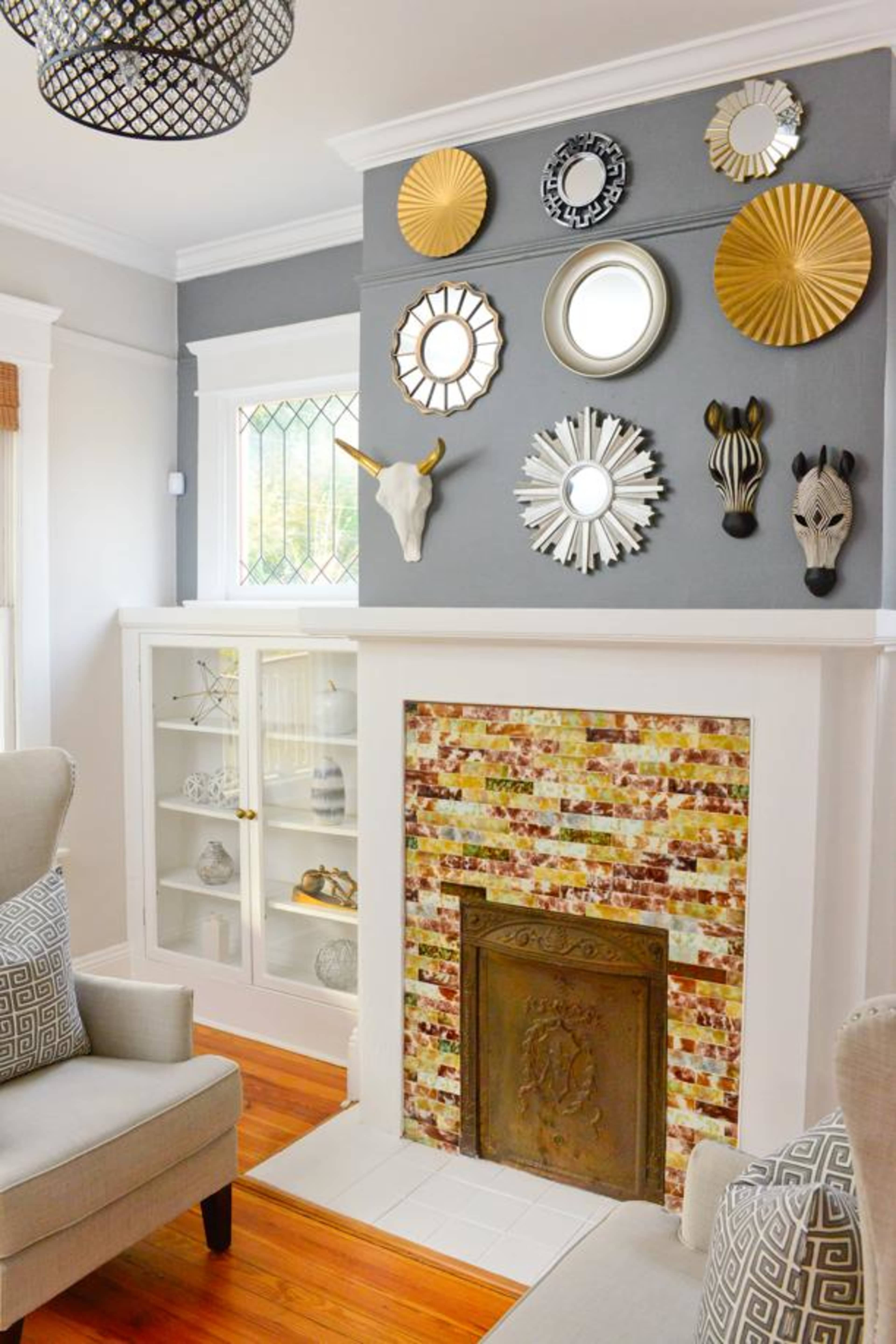 The image features a living room with a white fireplace surrounded by colorful tile and a wall adorned with various decorative mirrors and wall art.