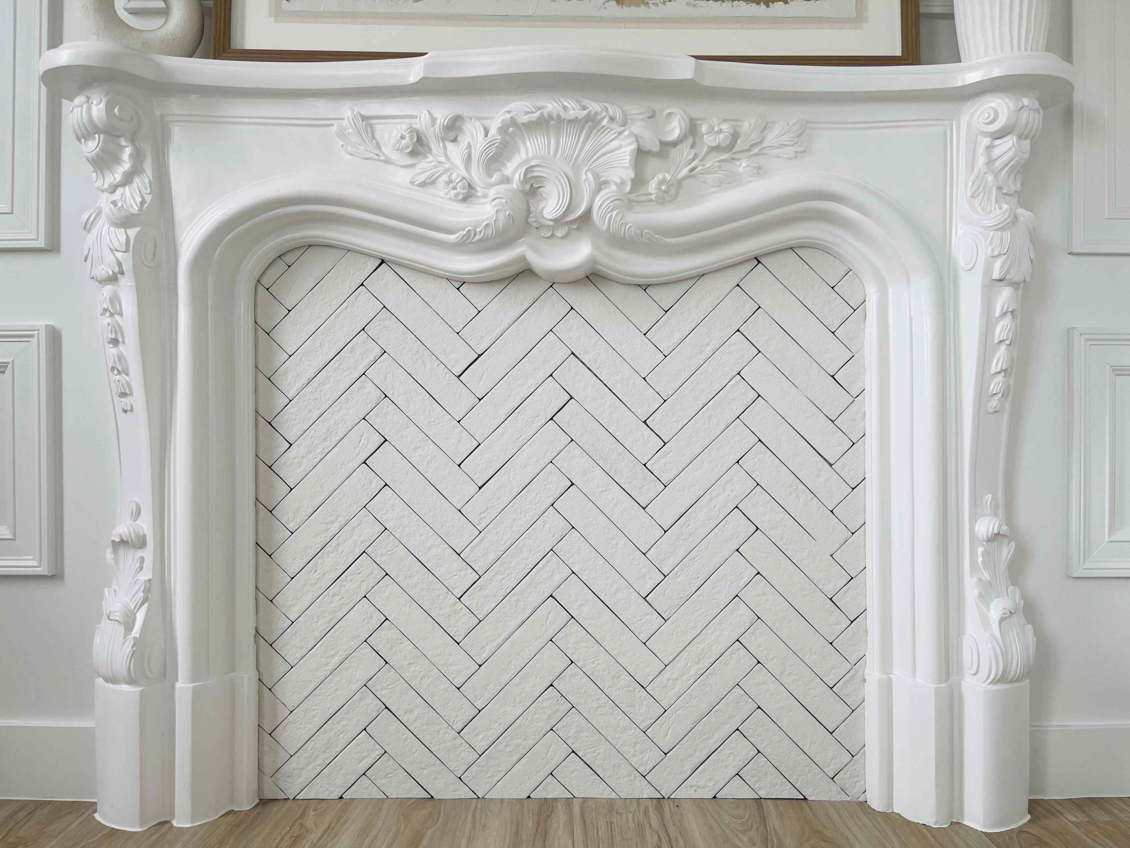 The image features an ornate white fireplace mantel with a herringbone-patterned hearth floor.