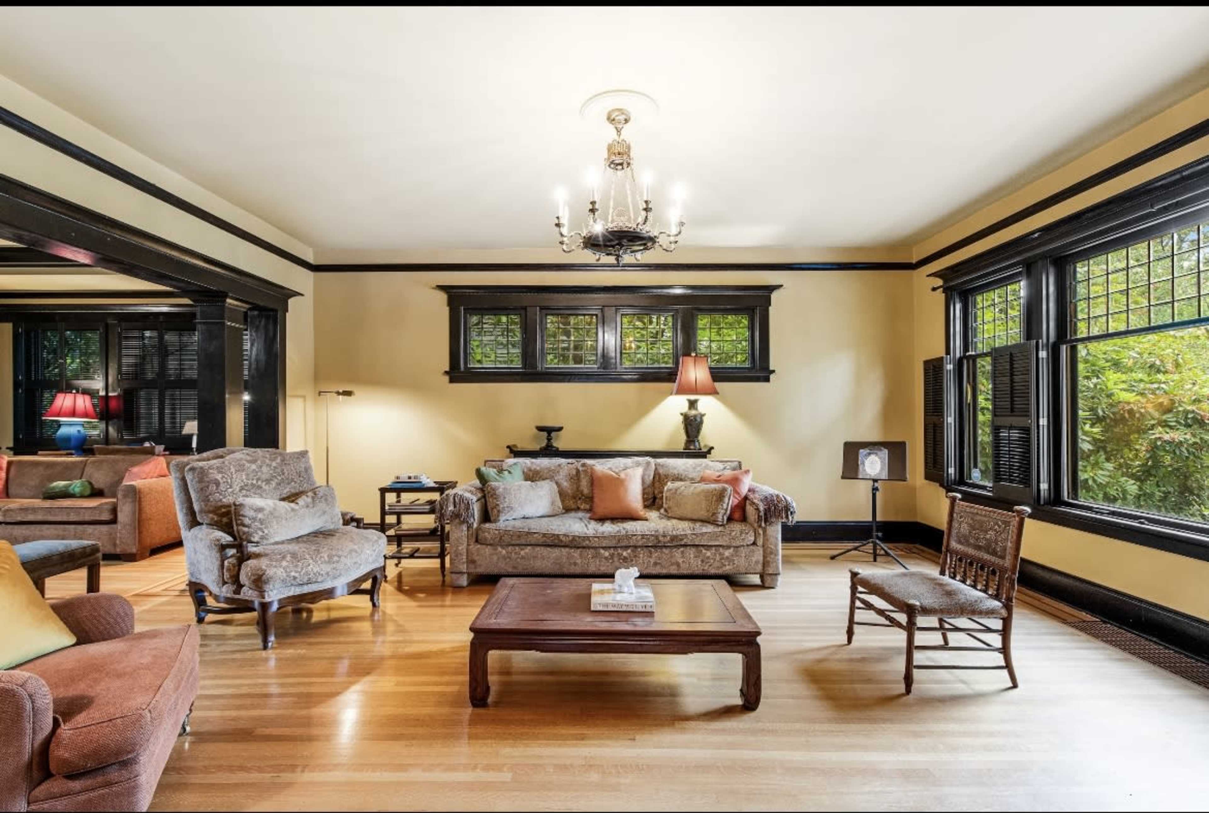 A spacious living room with a variety of seating options, a wooden coffee table, and large windows that let in natural light.