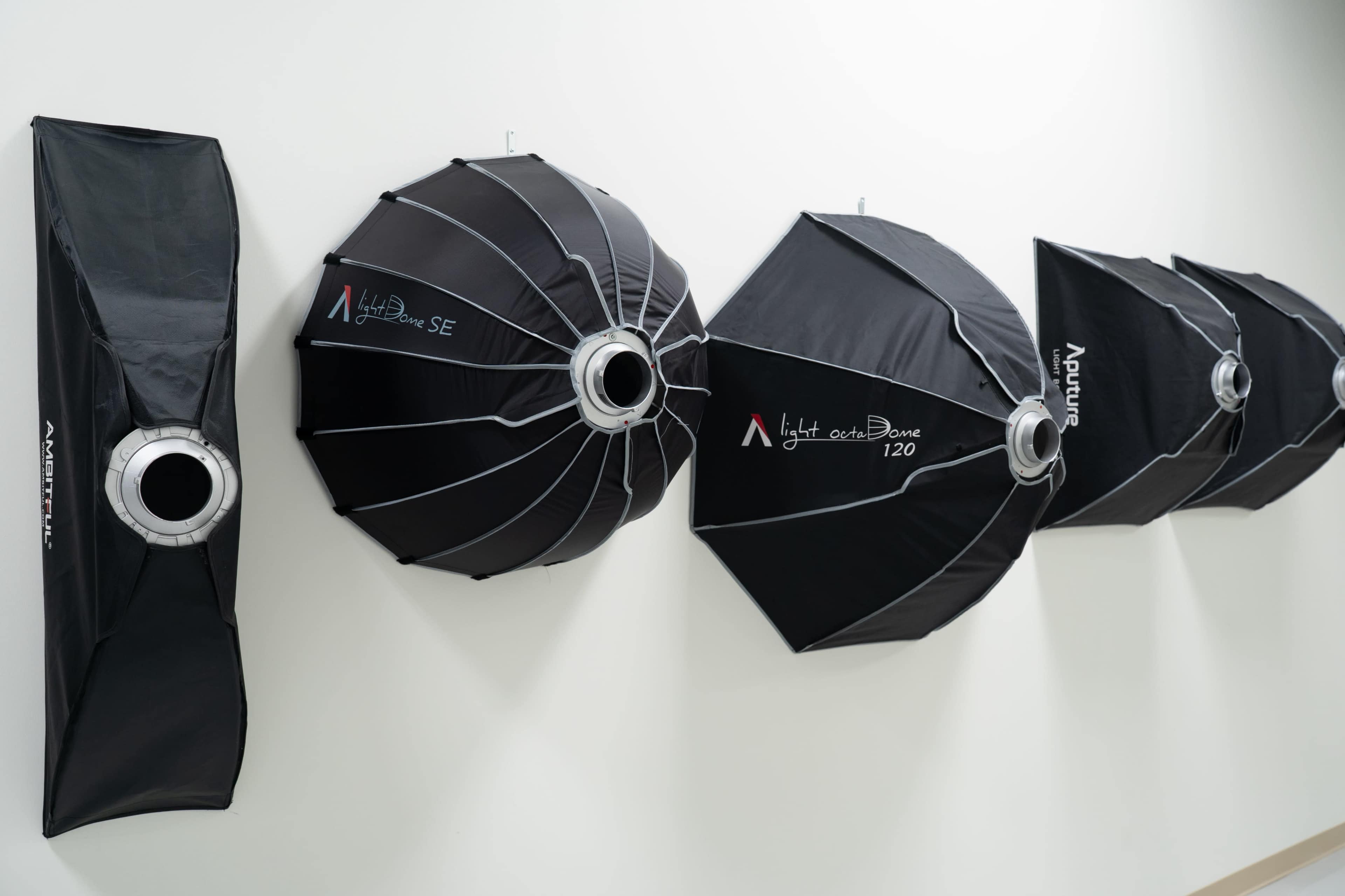 Several photography softboxes are mounted on a wall, showcasing different sizes and designs.