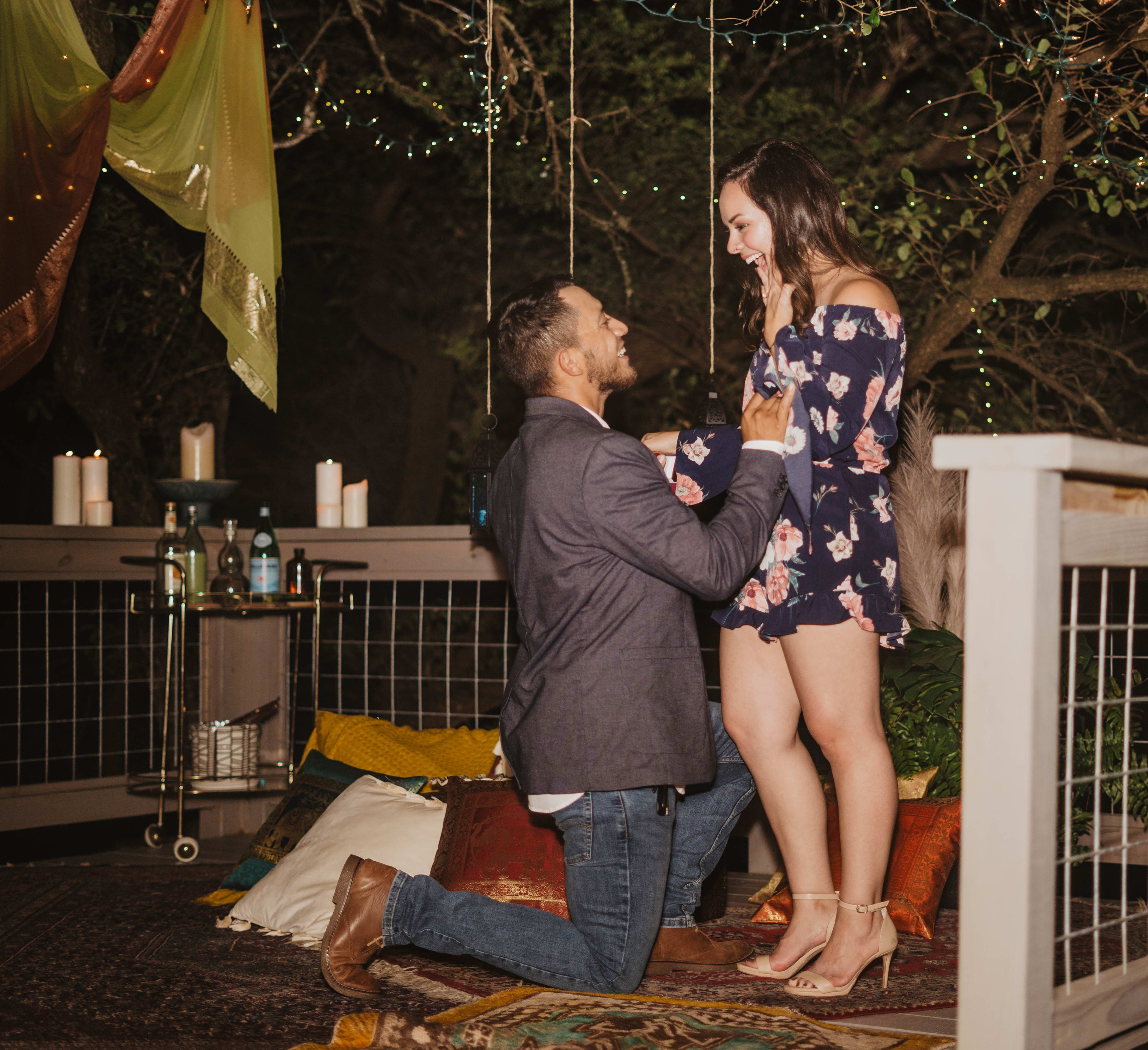 A couple on top of a boho rug at an outdoor party.