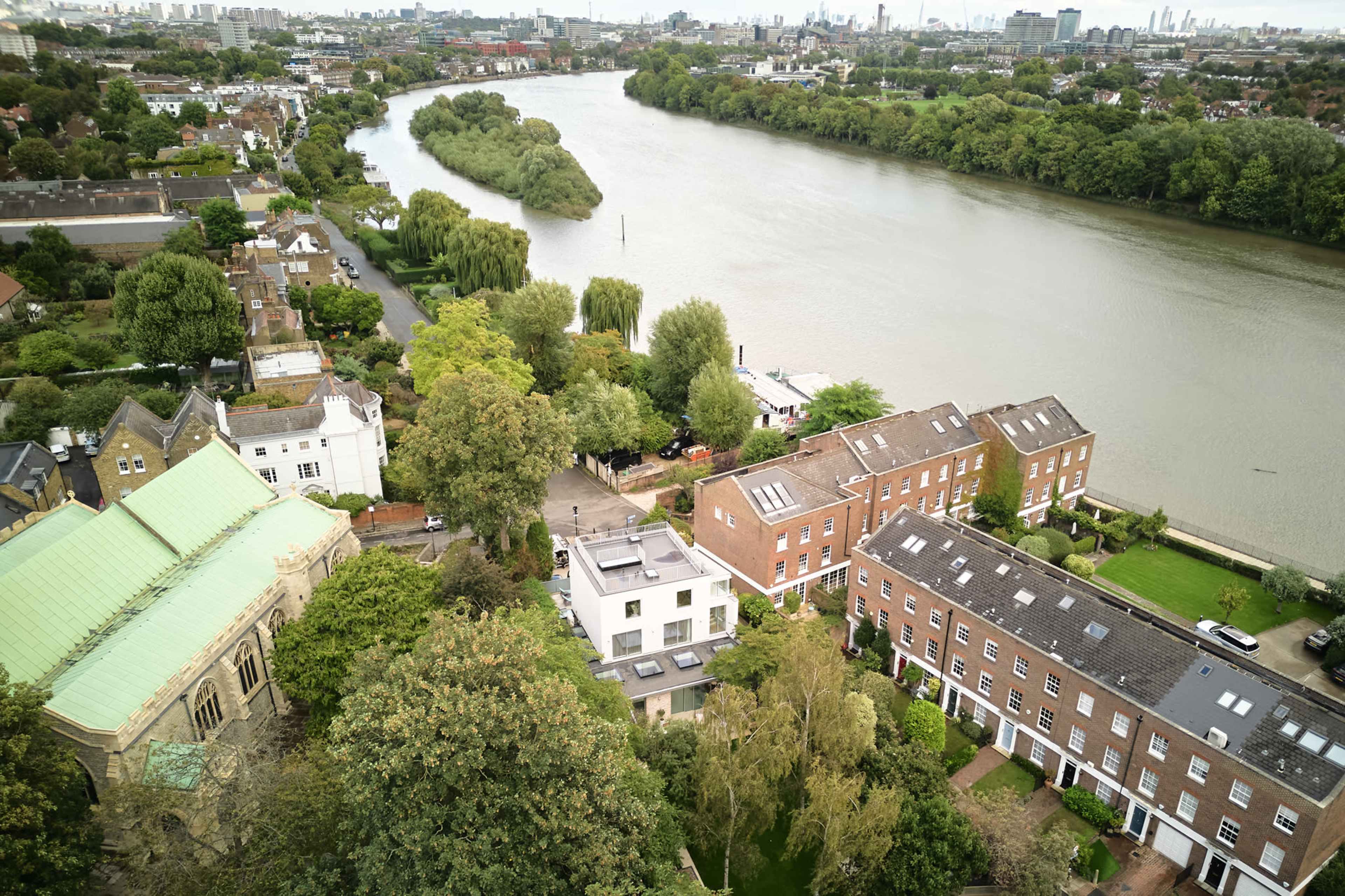 The image shows a river curving through an urban area with residential buildings and greenery along its banks.