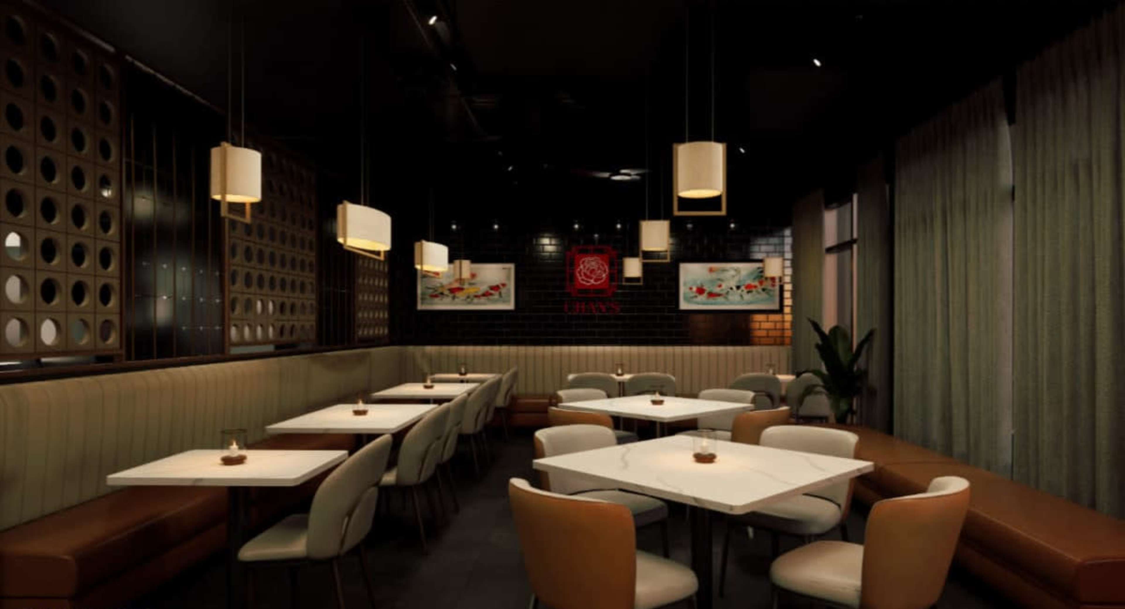 The image shows a modern restaurant interior featuring small tables with light-colored chairs, soft lighting fixtures, and decorative artwork on the walls.