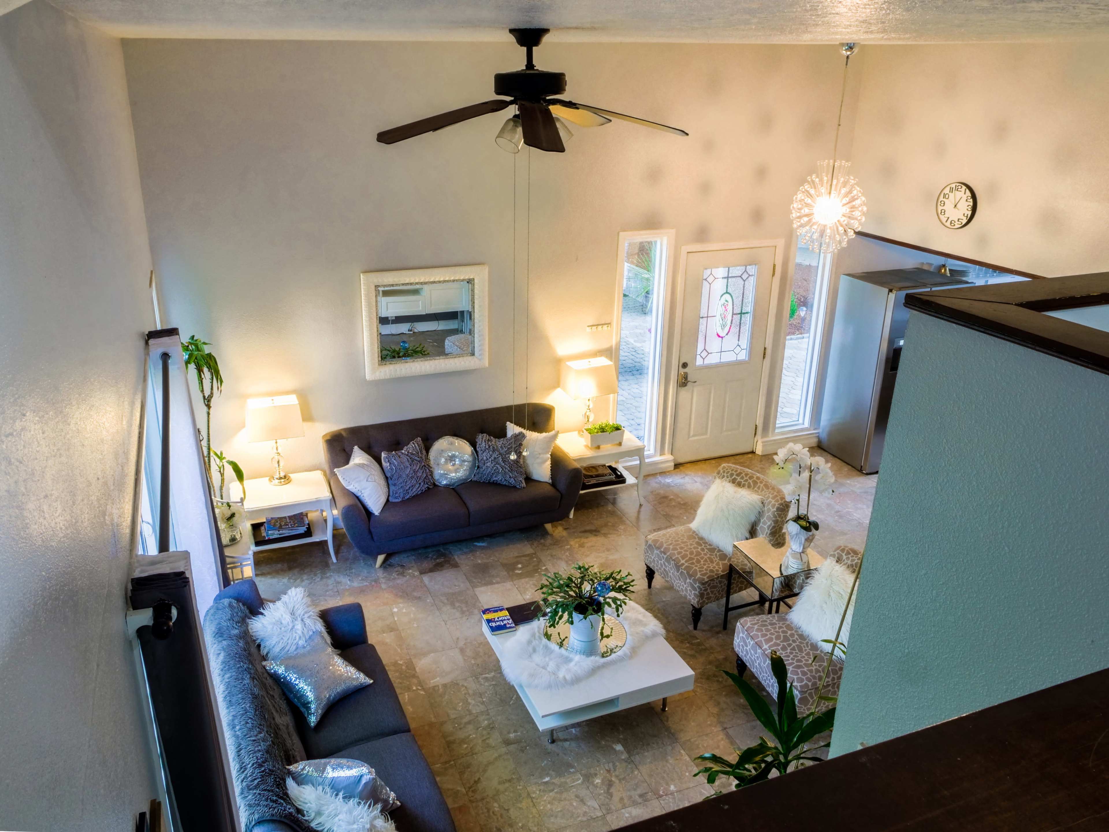 A modern living room with two sofas, a coffee table, and a front door leading to an outdoor area.