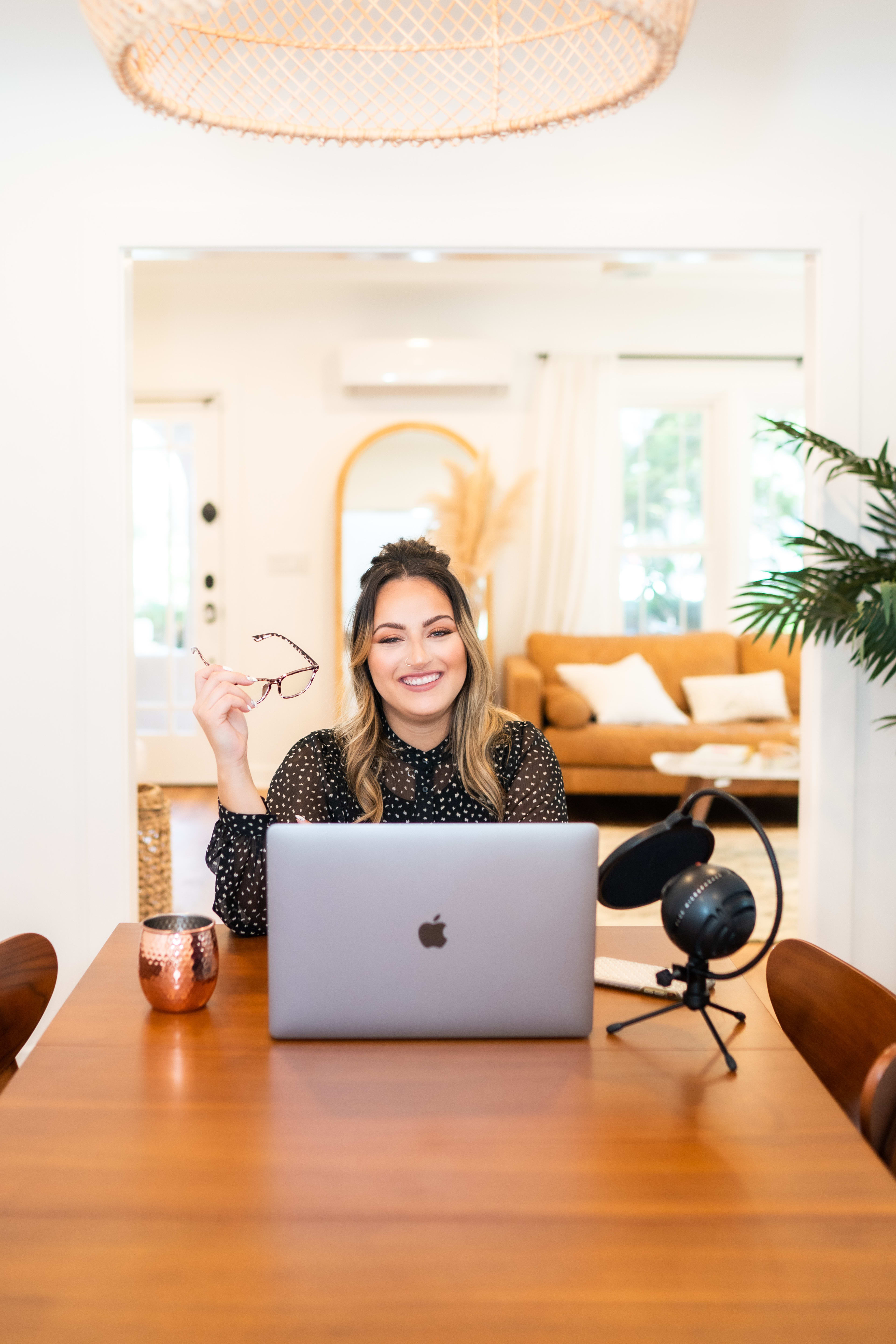 Une femme assise à une table avec un ordinateur portable dans une maison de style boho.