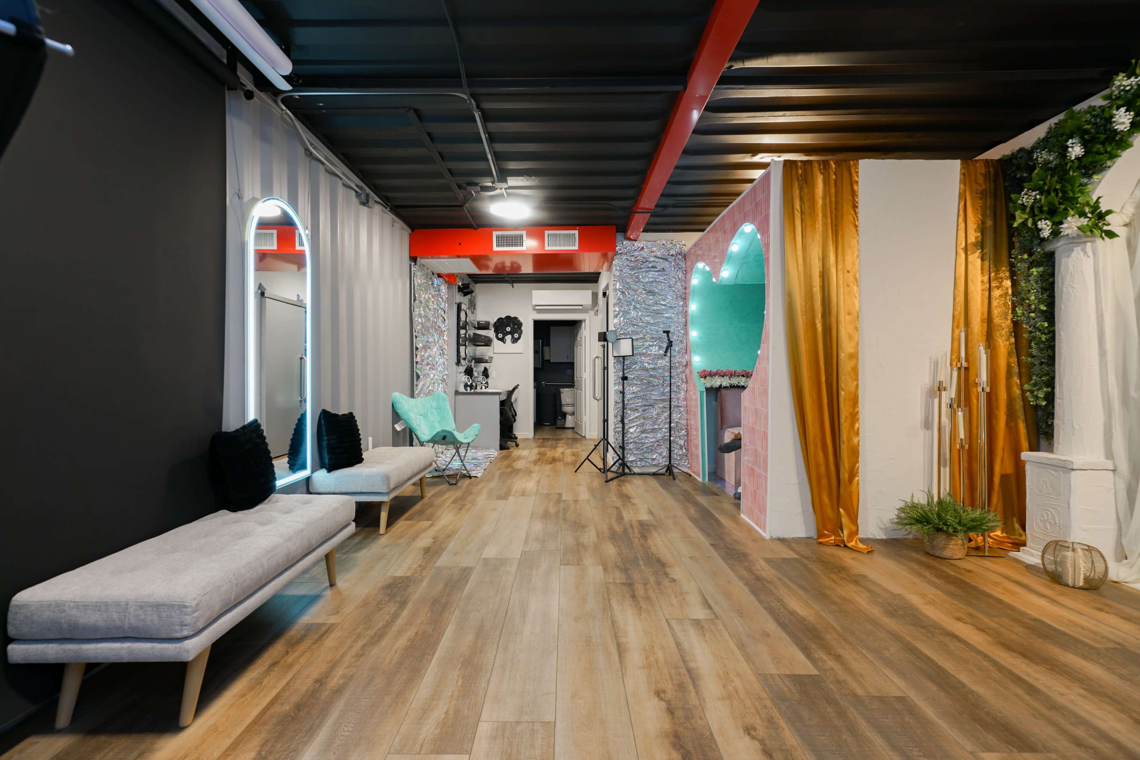 The image shows a spacious interior featuring a mix of modern design elements, including seating areas, decorative walls, and lighting fixtures.