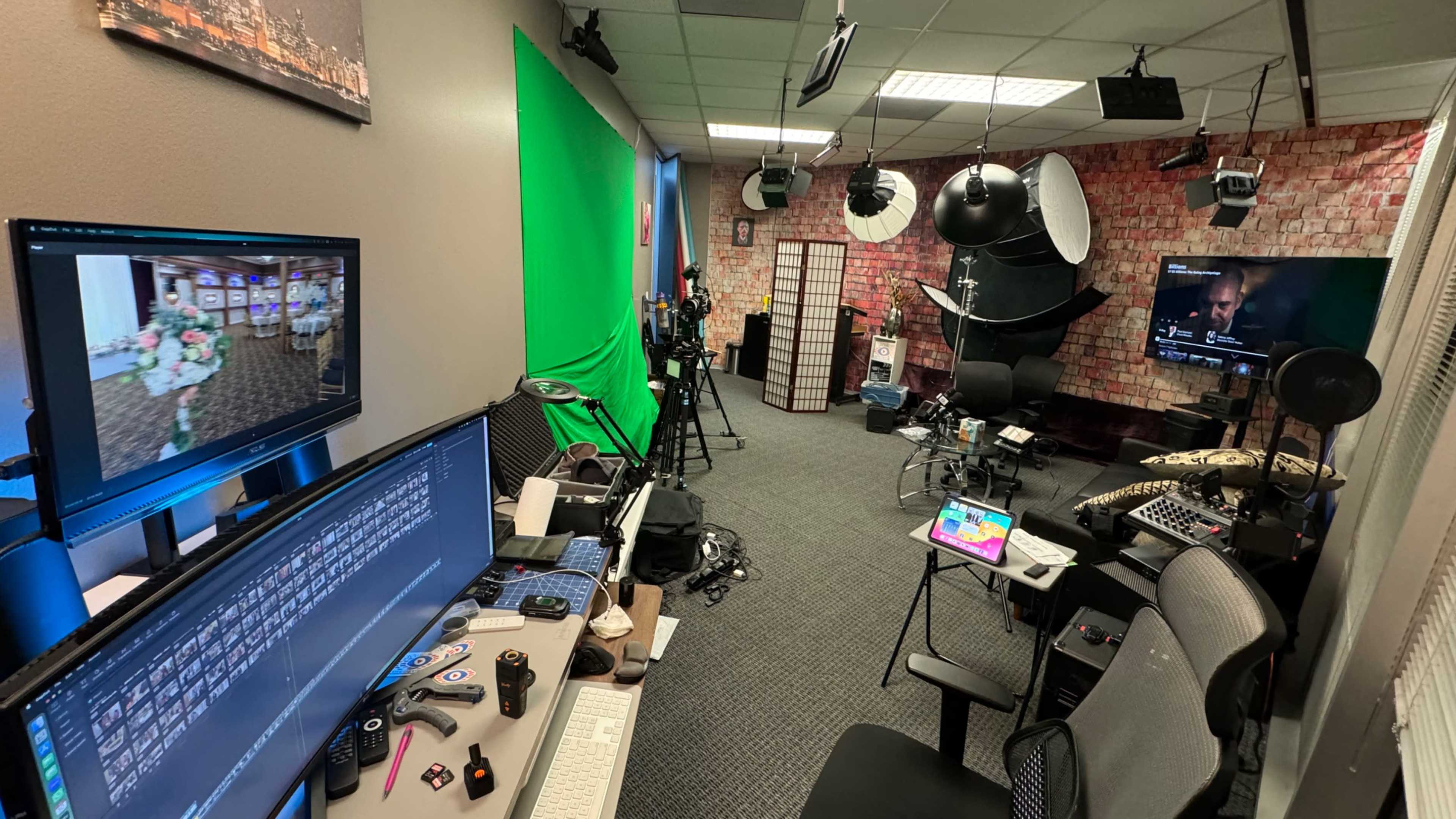 A recording studio equipped with a green screen, cameras, lighting equipment, and computer workstations.