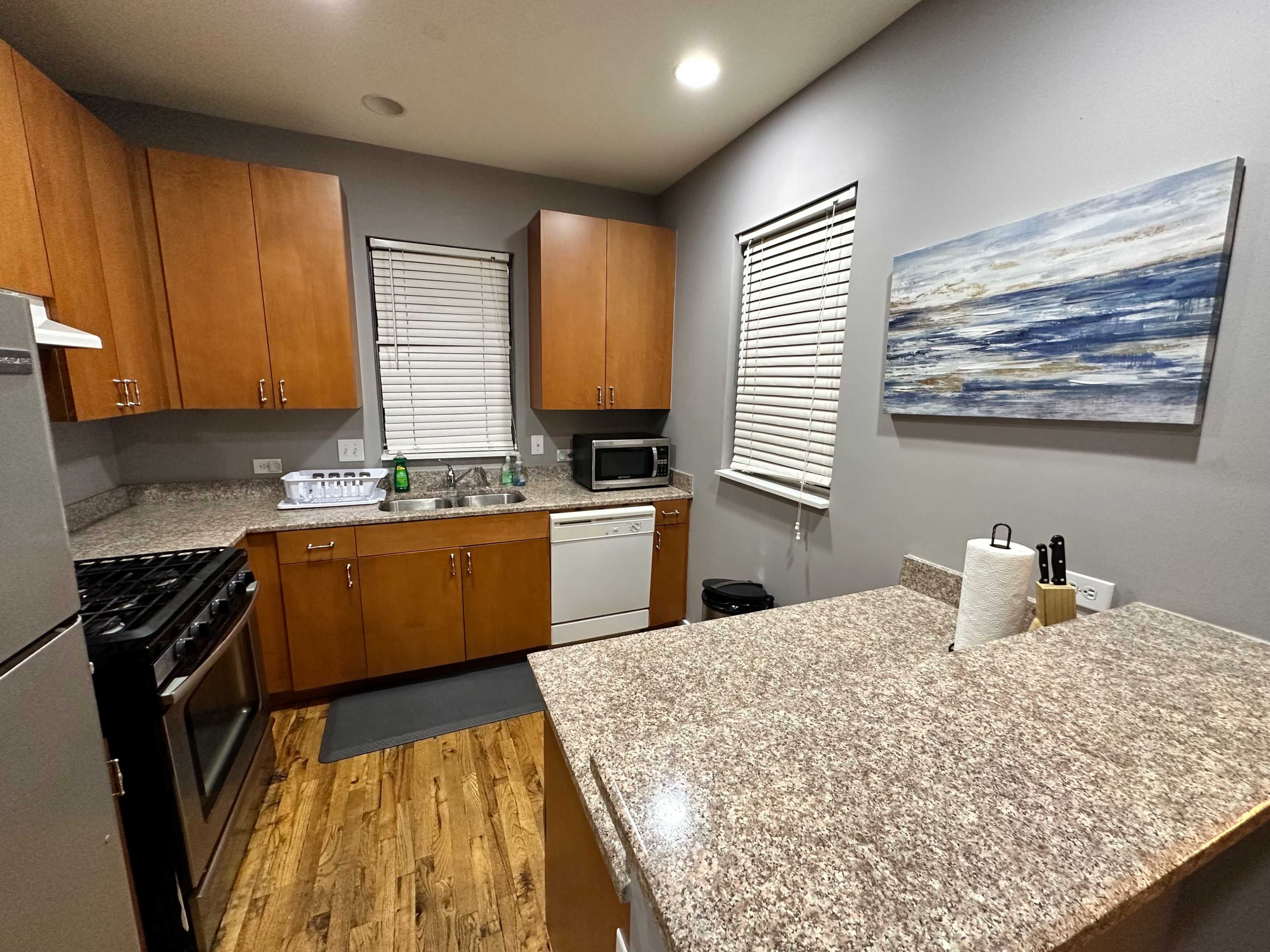 A modern kitchen with wooden cabinets, a countertop, a stove, and appliances like a refrigerator and dishwasher.