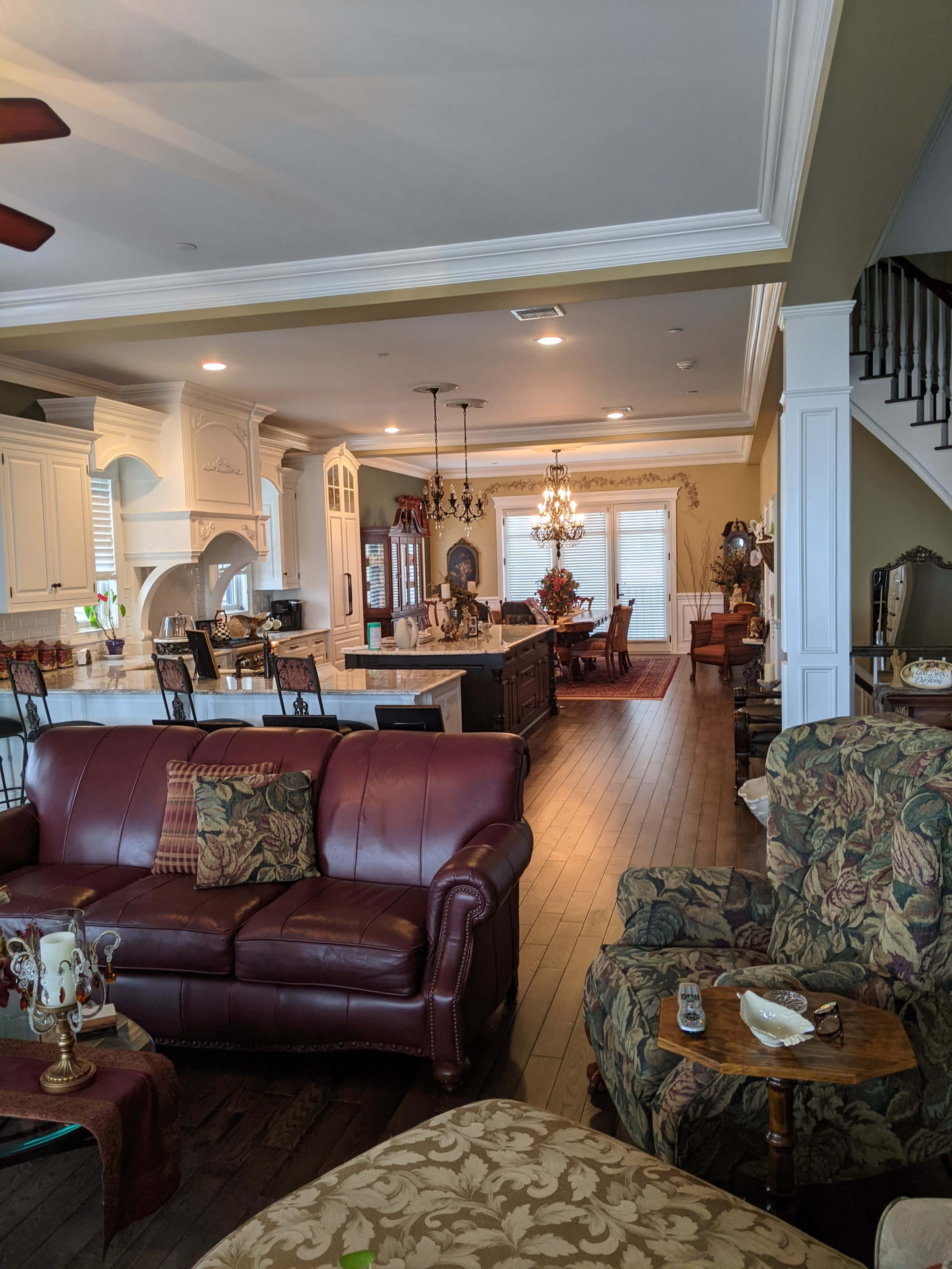 The image shows a spacious living area that includes a kitchen and dining space, furnished with various seating arrangements and decorative elements.