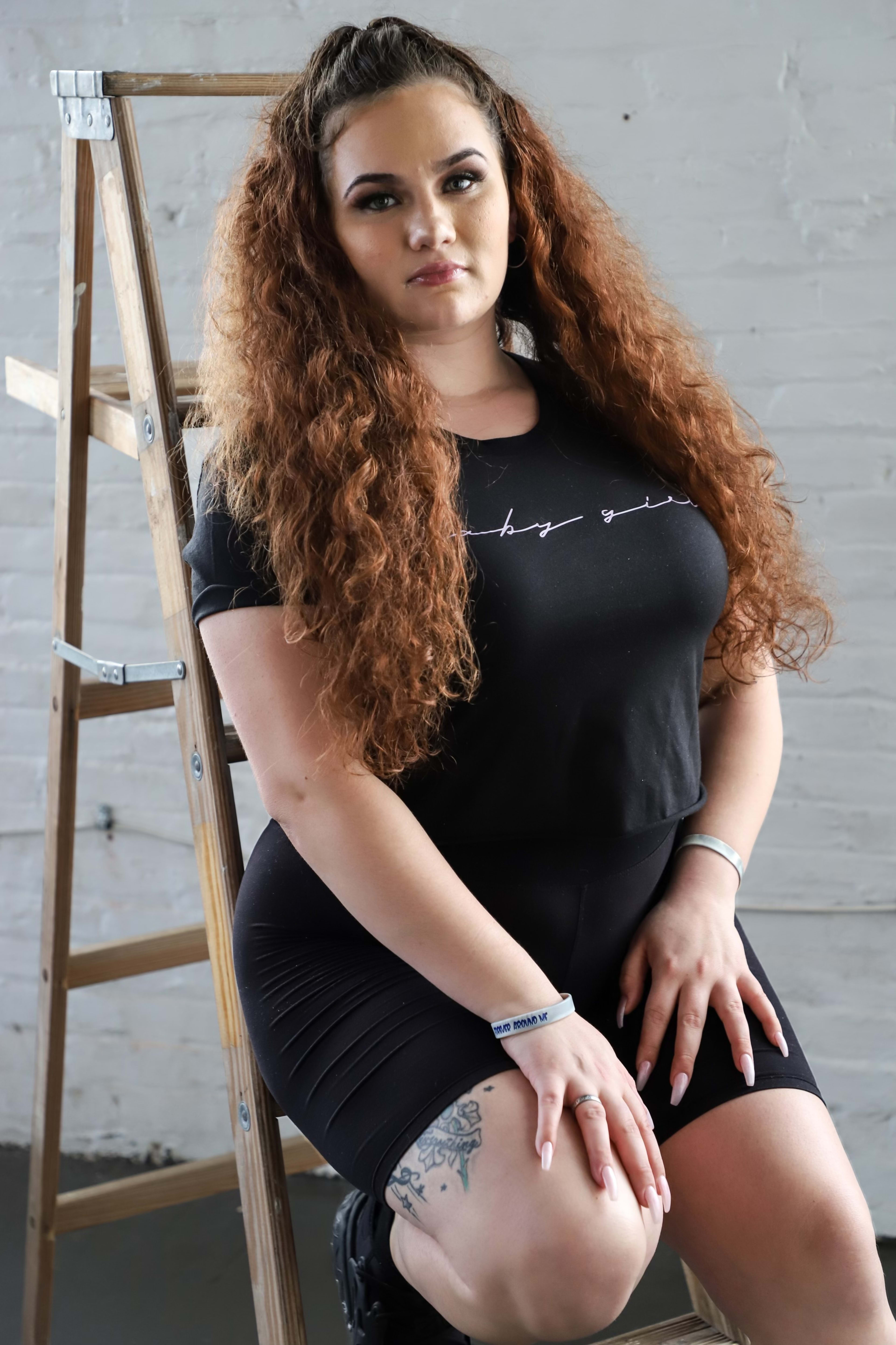 Une femme posant pour un portrait sur un escabeau lors d'un shooting photo.